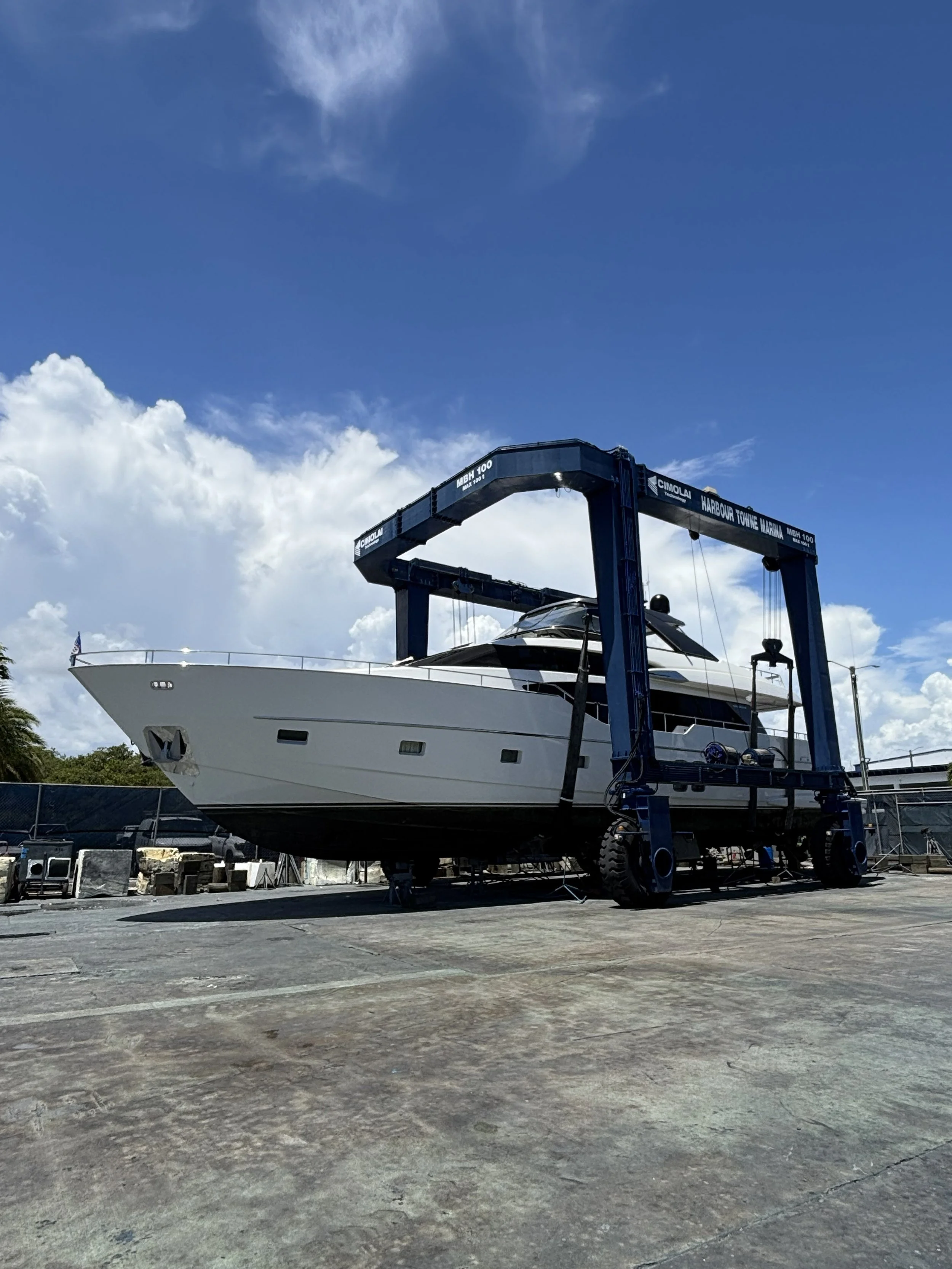Large yacht on a travel lift hoisted at a marina