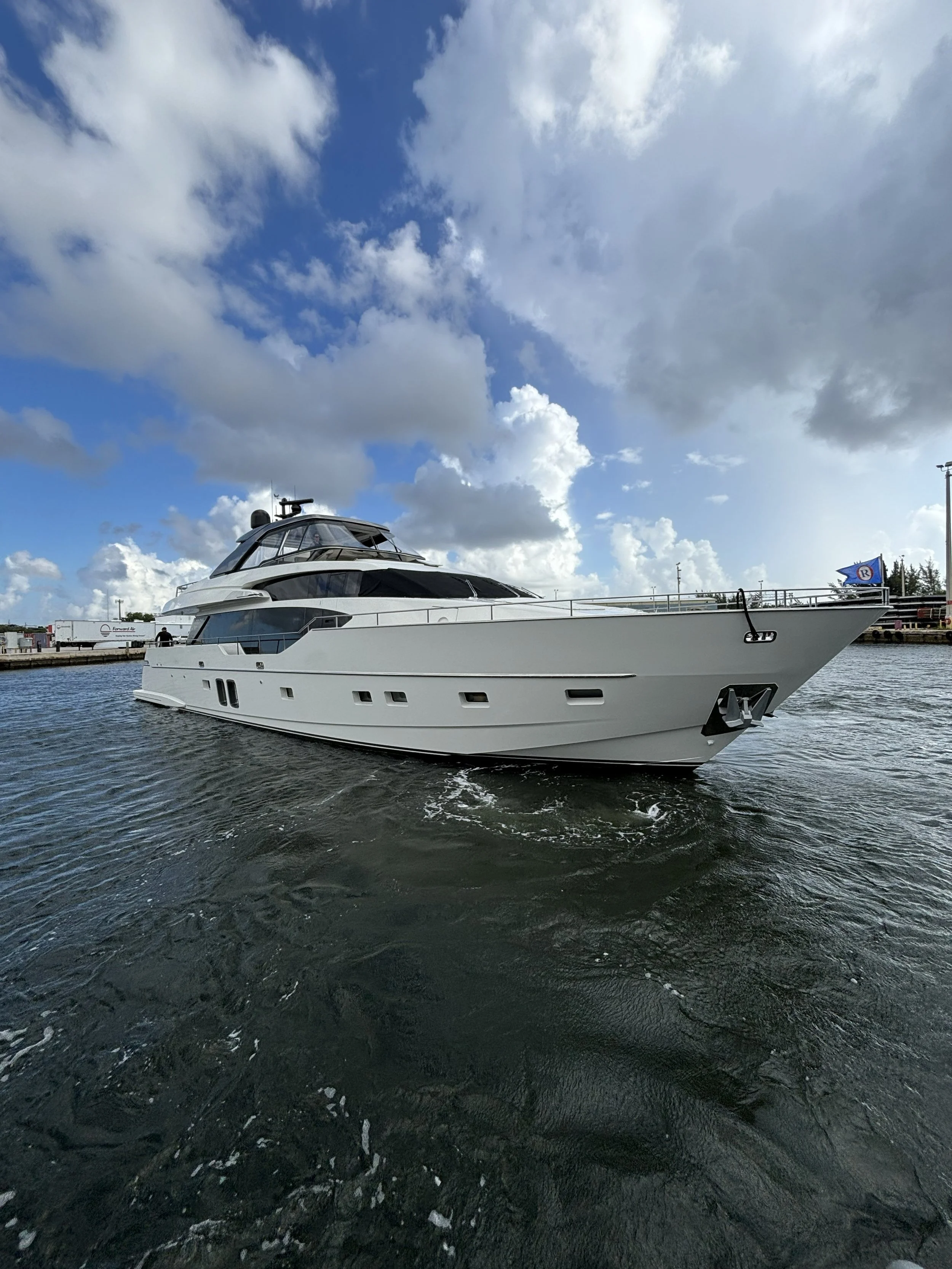 A large white yacht docked at a marina