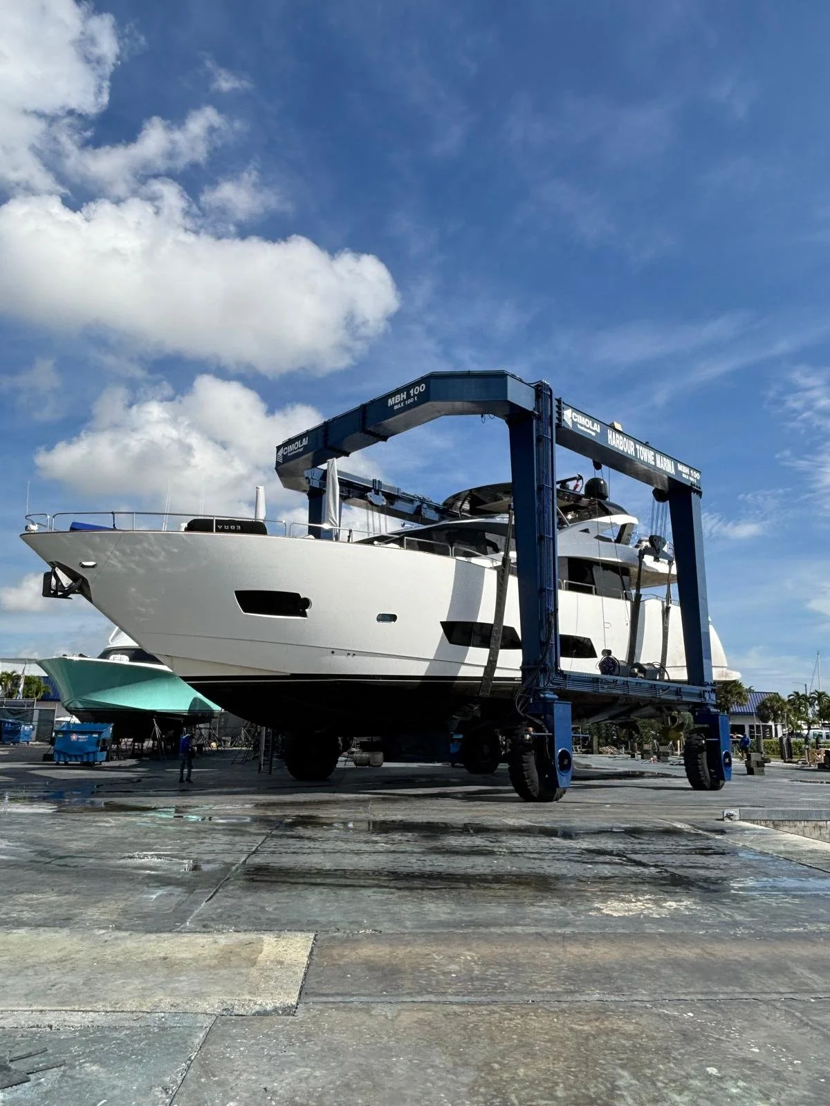 A large yacht is being hauled out on large lift at a marina