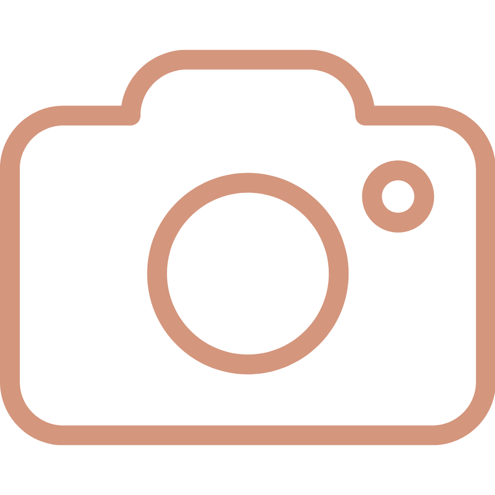 Outline illustration of a camera with a large circular lens in the center and a smaller circular button on the top right.