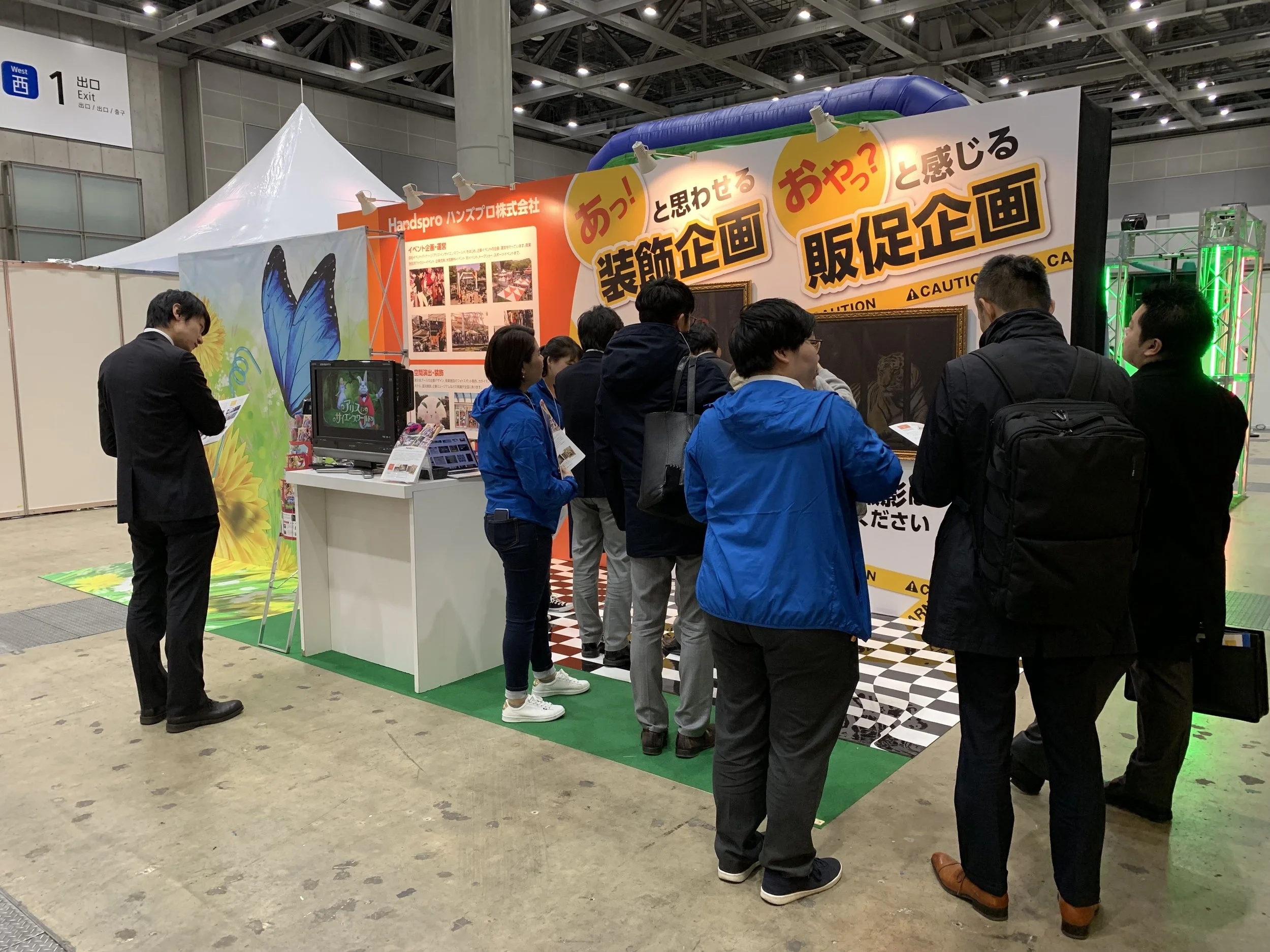 大きな看板のある展示ブースに集まった来場者