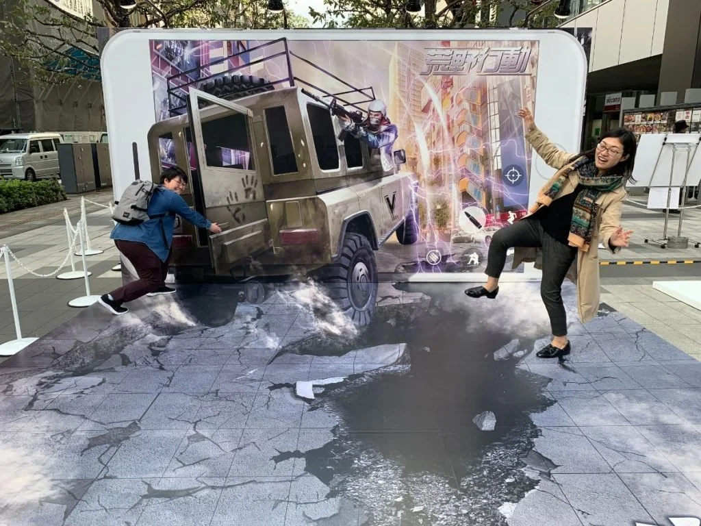 Outdoor event illusion: a car drives out of a smartphone screen (Japan)