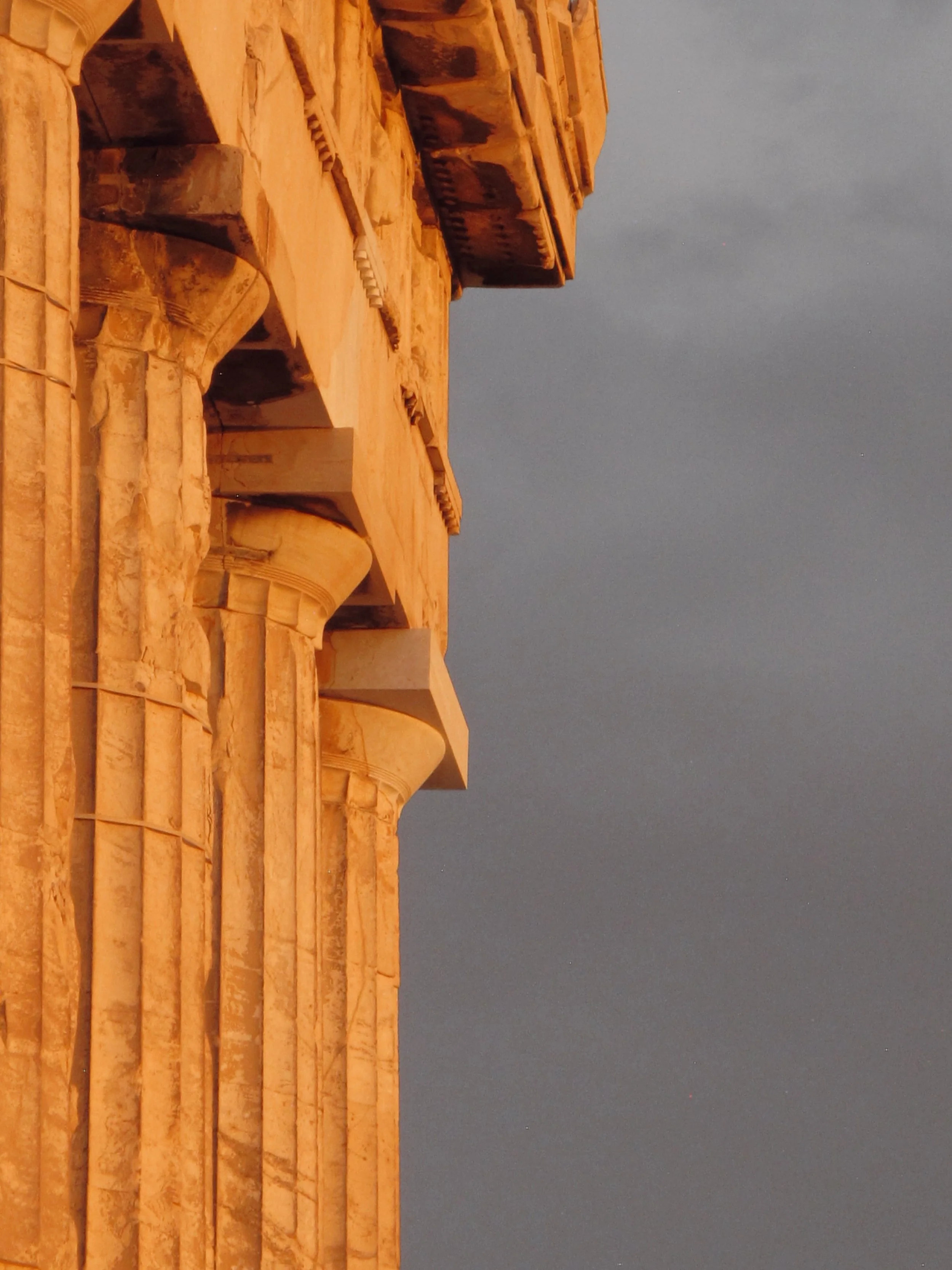 Ancient stone ruins with stairs and architectural details against a dark sky.