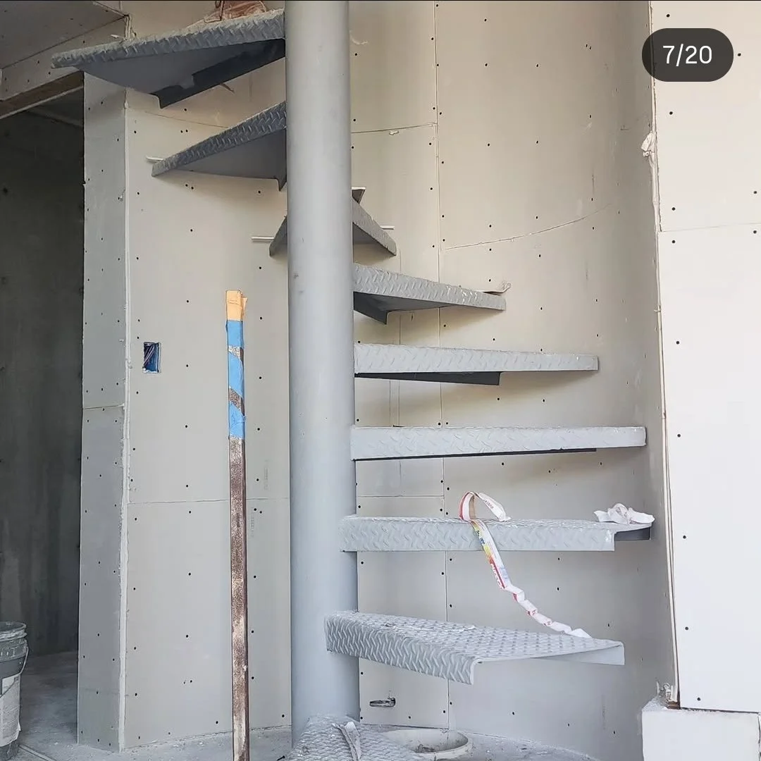 Spiral staircase stairwell with new drywall hung and screwed, residential project in Brea, CA