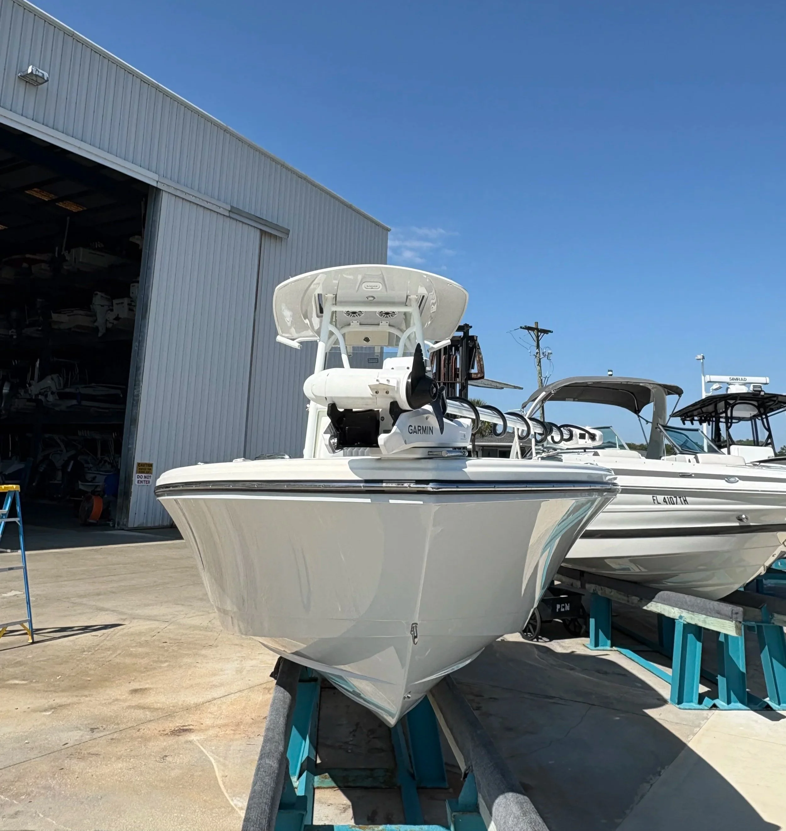 Center console boat on a trailer outside a boatyard service shop
