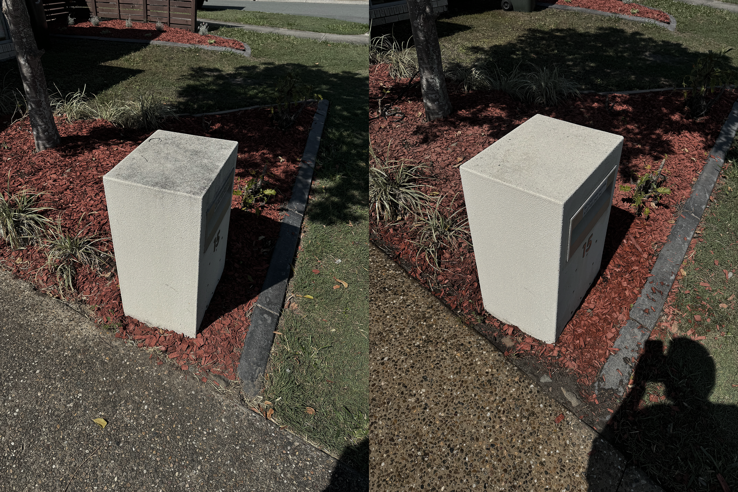 Concrete blocks with electrical equipment, with landscape plants and trees behind them, on a sidewalk in a landscaped area.