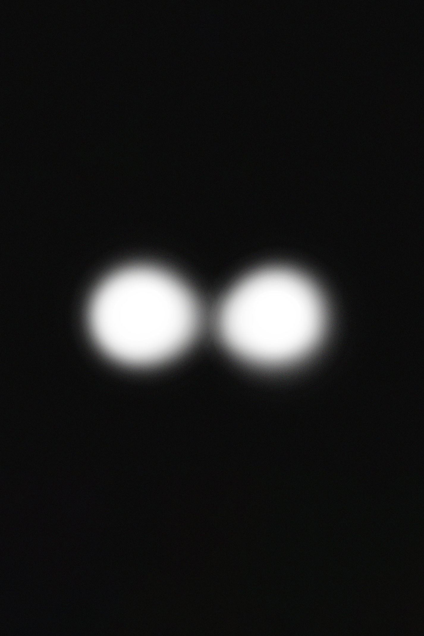 Close-up of a dark electronic device with two circular buttons at the bottom.