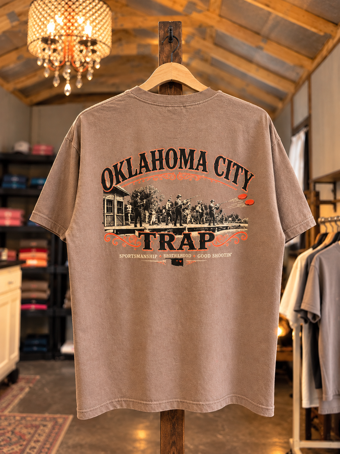 Tan custom trap team T-shirt with Oklahoma City lettering and a trap shooting graphic.