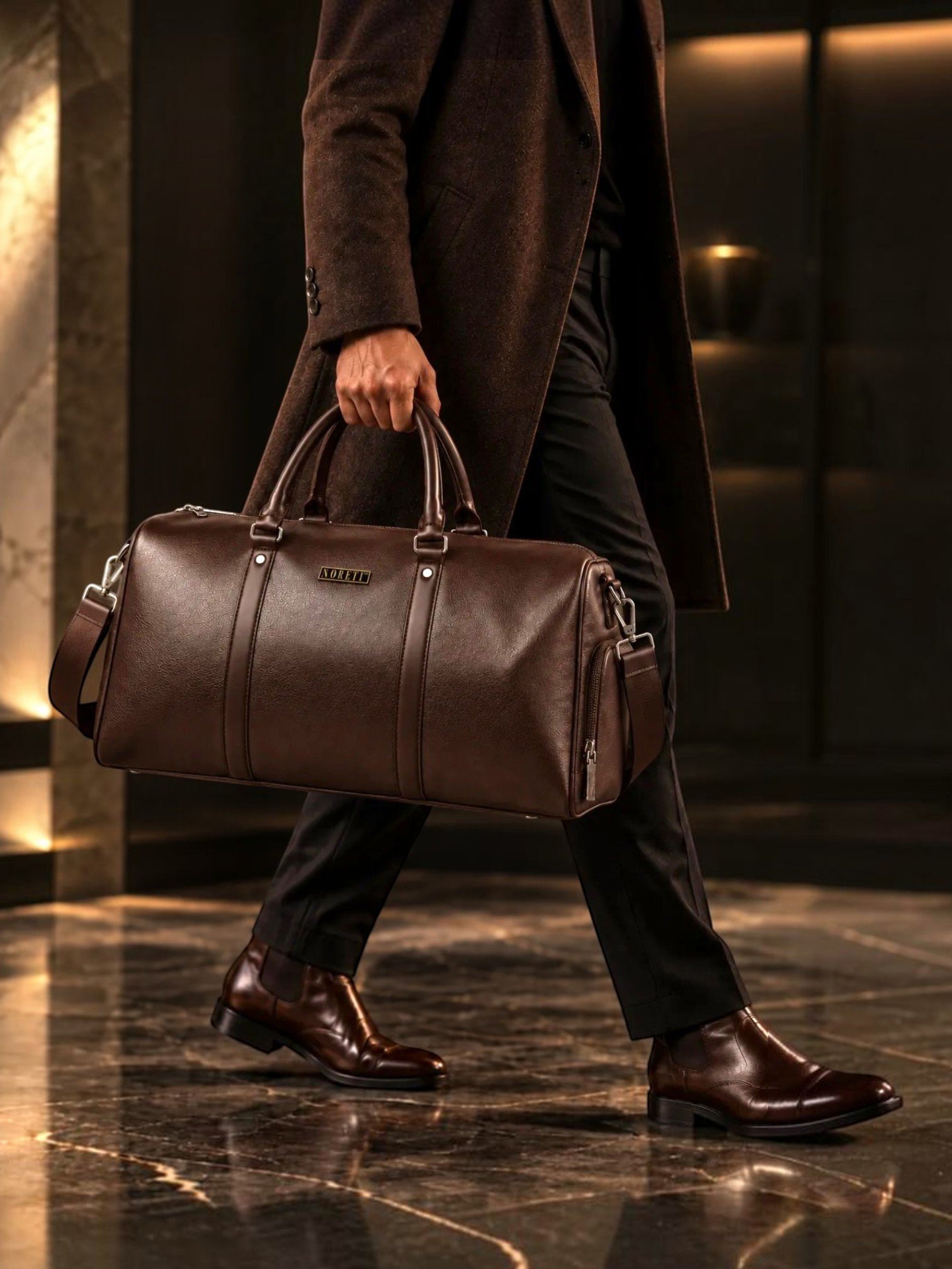 Male model carrying the NORETI Ravelle espresso brown vegan leather weekender travel bag with a sophisticated smart casual outfit.