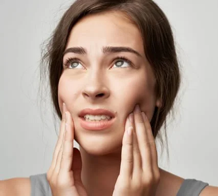 Woman holding her jaw from teeth clenching and grinding