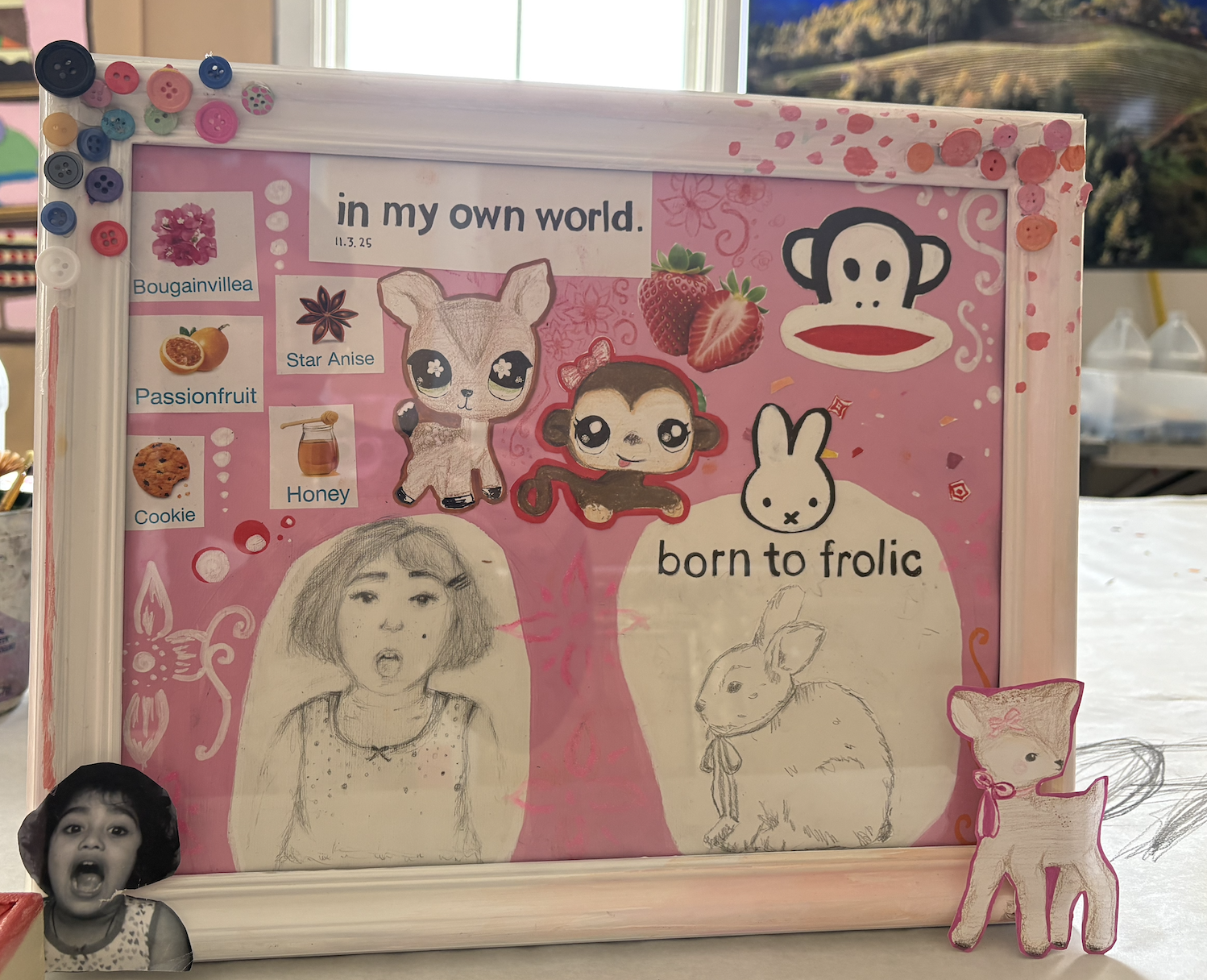 A pink scrapbook page featuring drawings of a girl, a bunny, a monkey, a dog, and a cat, decorated with strawberries, ice cream, and flowers, with stickers of animals and food items, and the text 'in my own world' and 'born to frolic'.