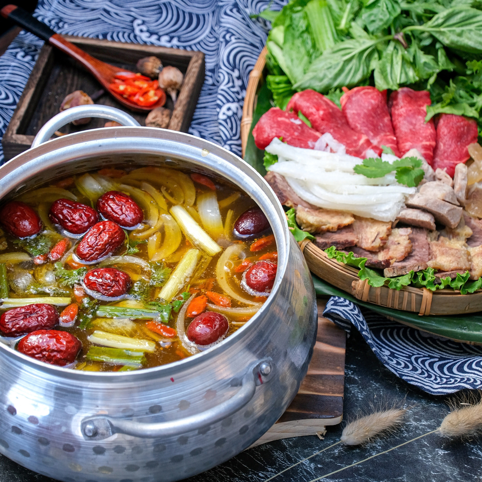 Crawfish & Hotspot’s signature beef hot pot with savory broth, red dates, vegetables, and herbs, served alongside sliced beef and fresh hot pot ingredients.