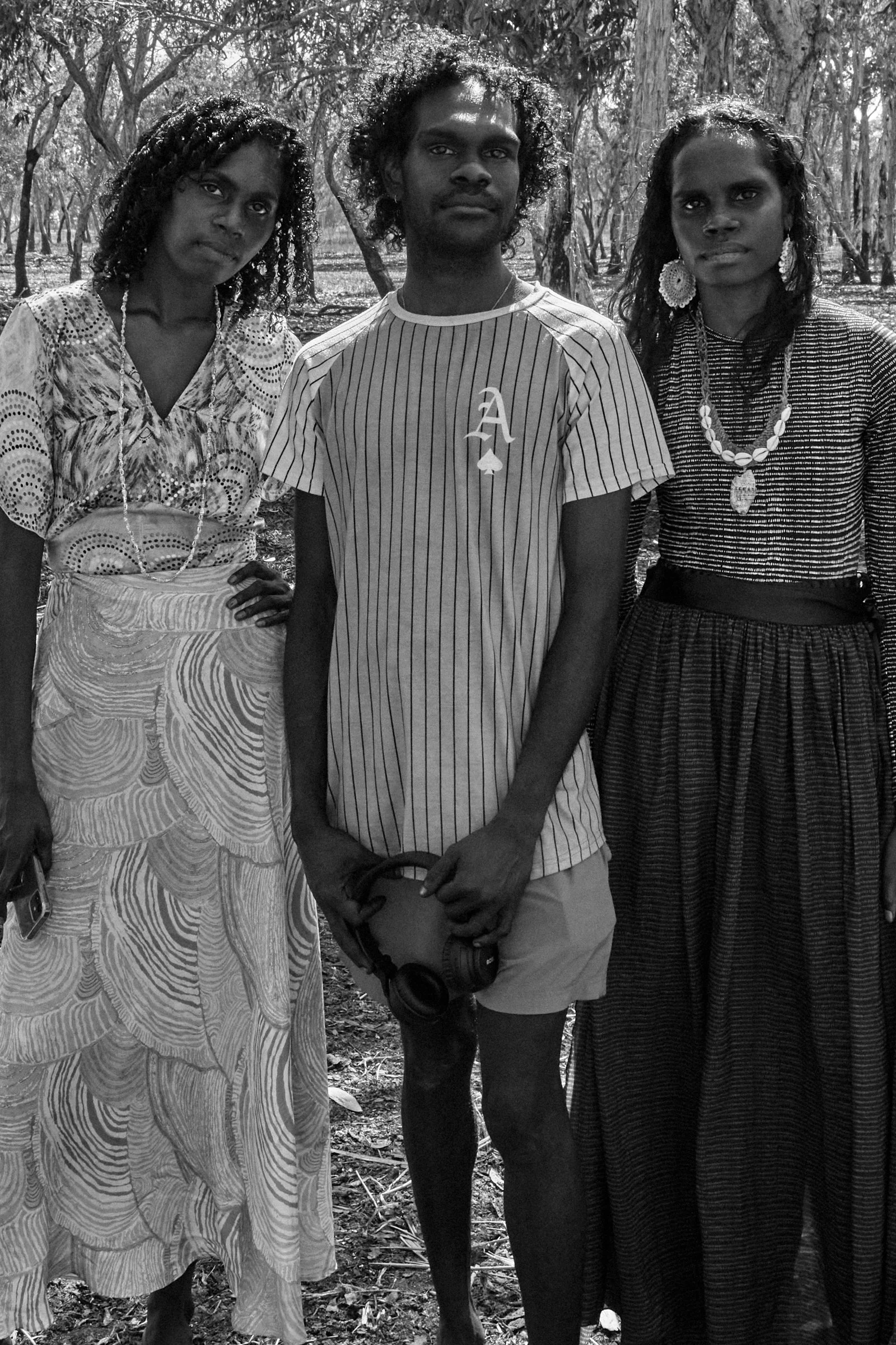 Jack Minmidi and Tarlisa Gaykamangu standing with another person outdoors in a wooded setting during a ḺUNDU project.