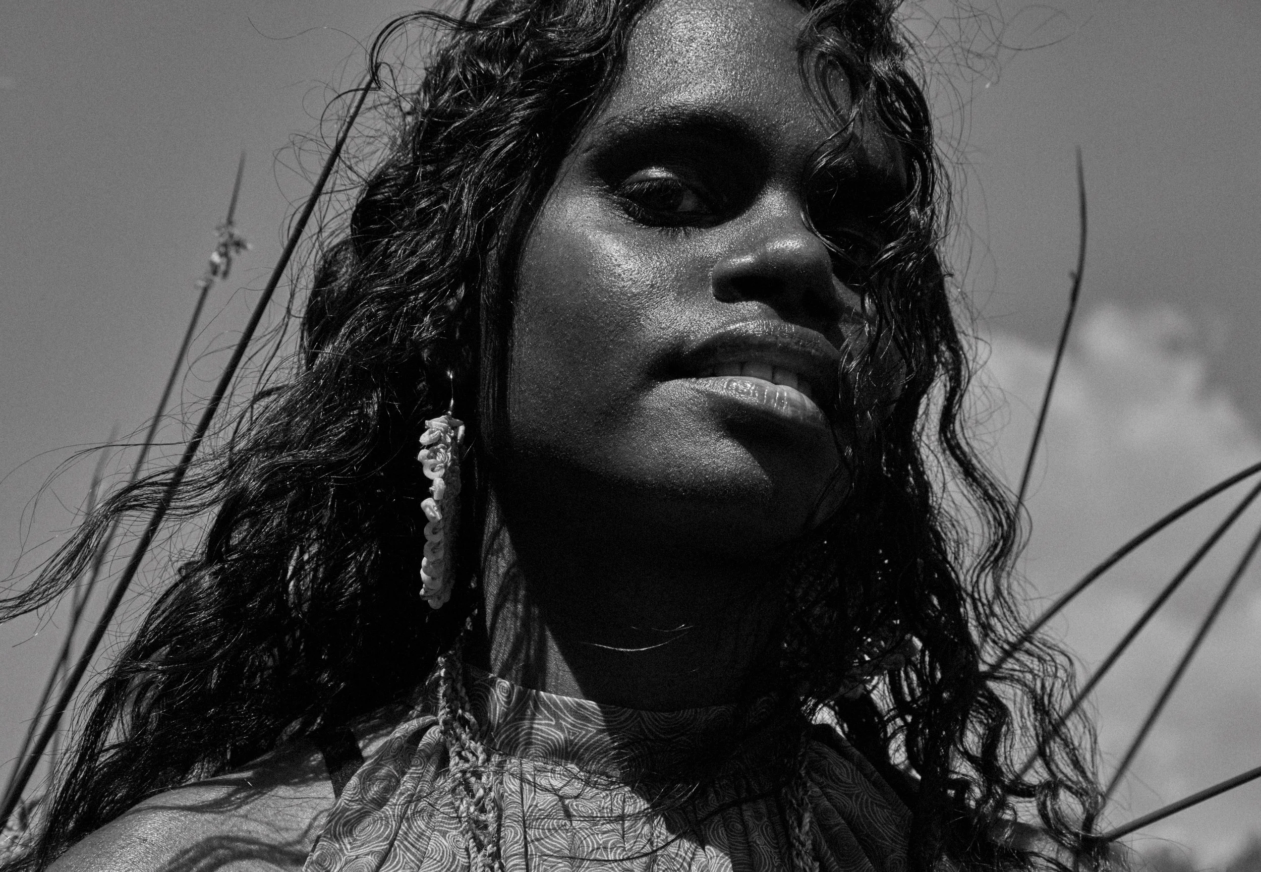 Black-and-white close-up portrait of Tarlisa Gaykamangu, with curly hair and a patterned scarf.