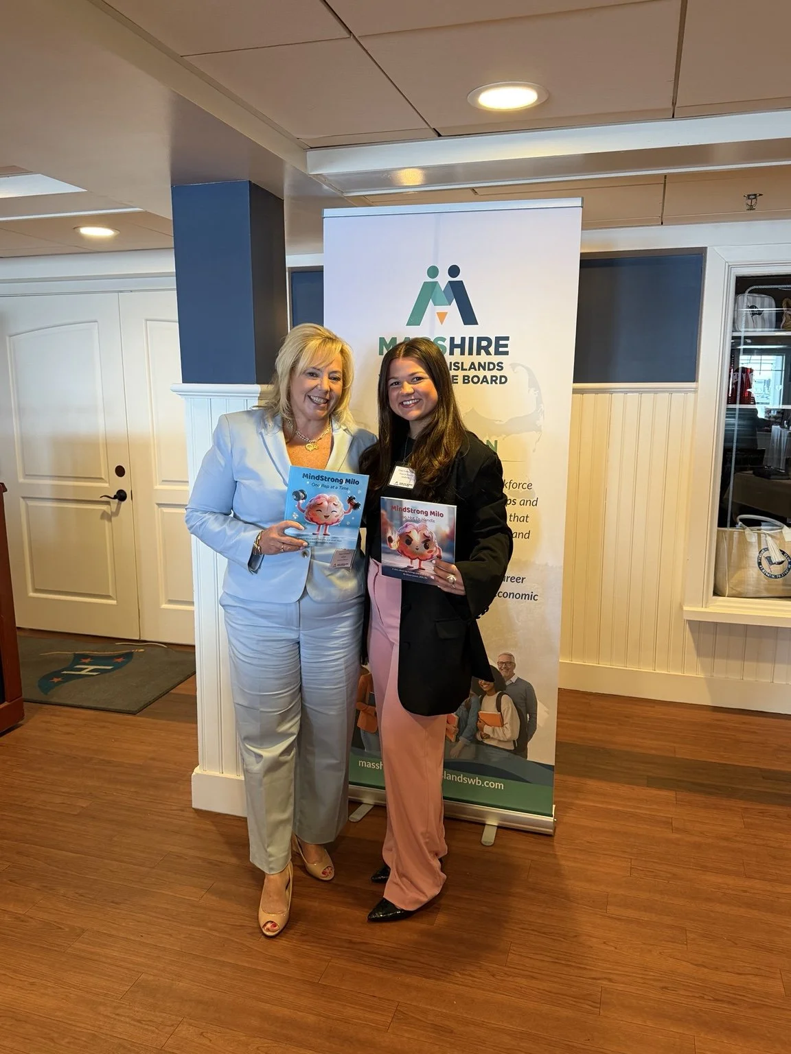 MindStrong at the Cape and Islands Youth Symposium, with two attendees holding MindStrong Milo picture books.