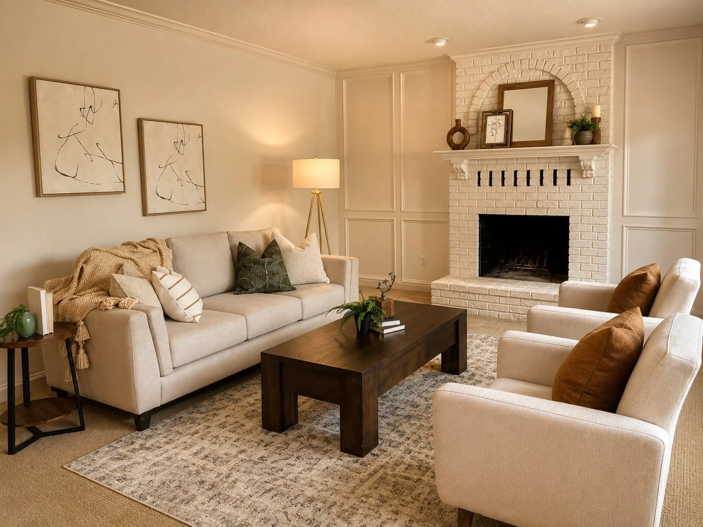 Inviting living room stage with cream seating, a dark wood. coffee table, cream brick fireplace, warm lighting, and natural décor.