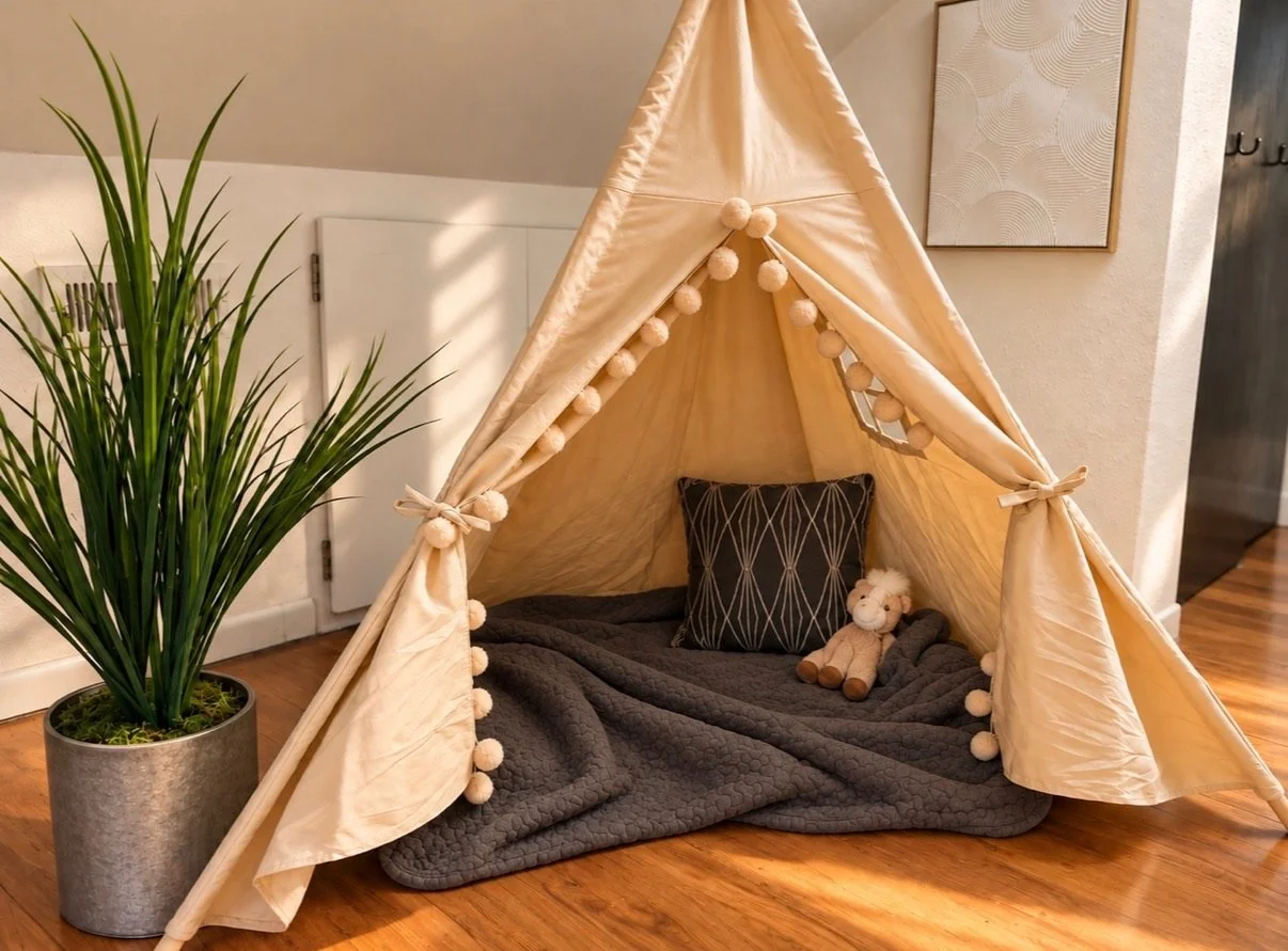 Cozy kids play area styled with a fabric tent, floor  cushions, greenery, and playful decorative details.