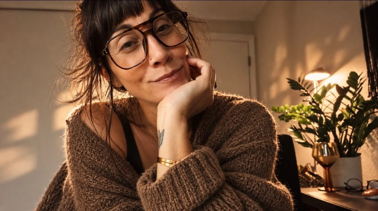 Interior designer and stylist in a warmly lit, relaxed home setting.