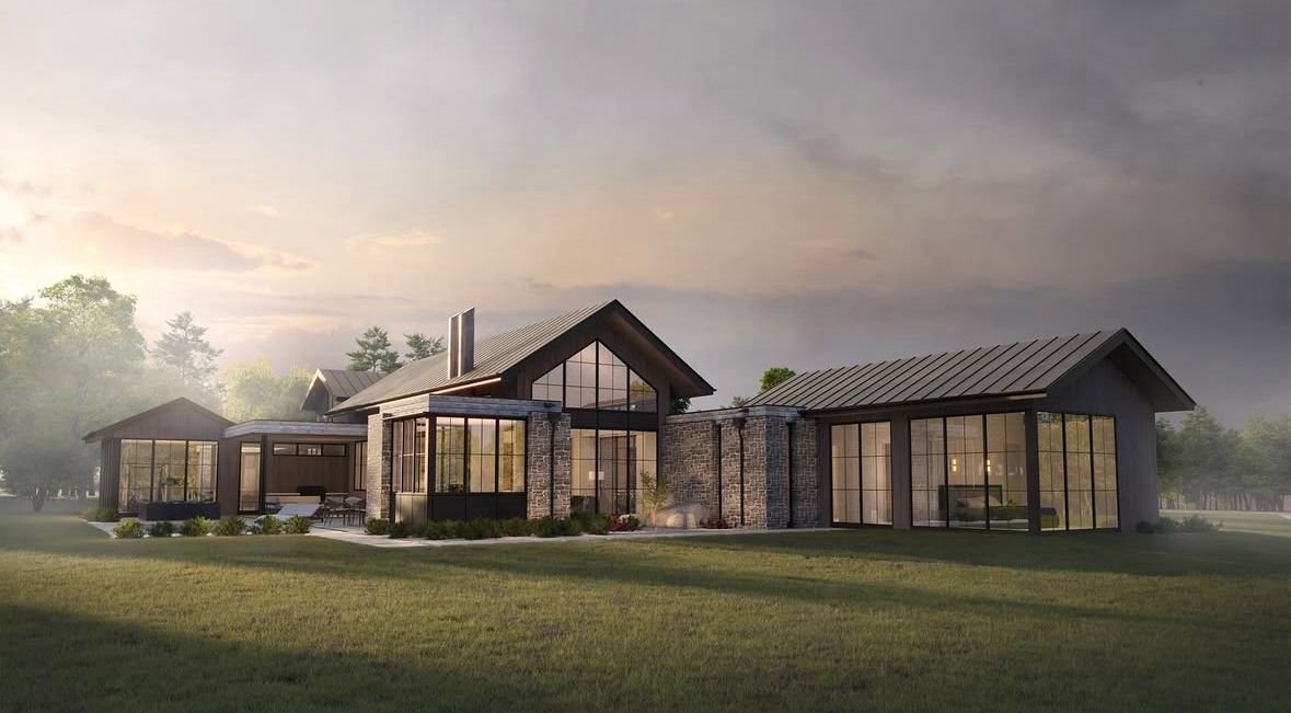 A modern house with large glass windows, brick and dark wood exterior, situated on a grassy lawn with trees in the background.