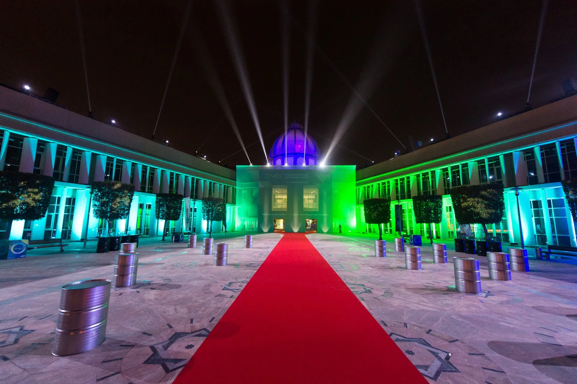 Red carpet entrance lit in green at a night event