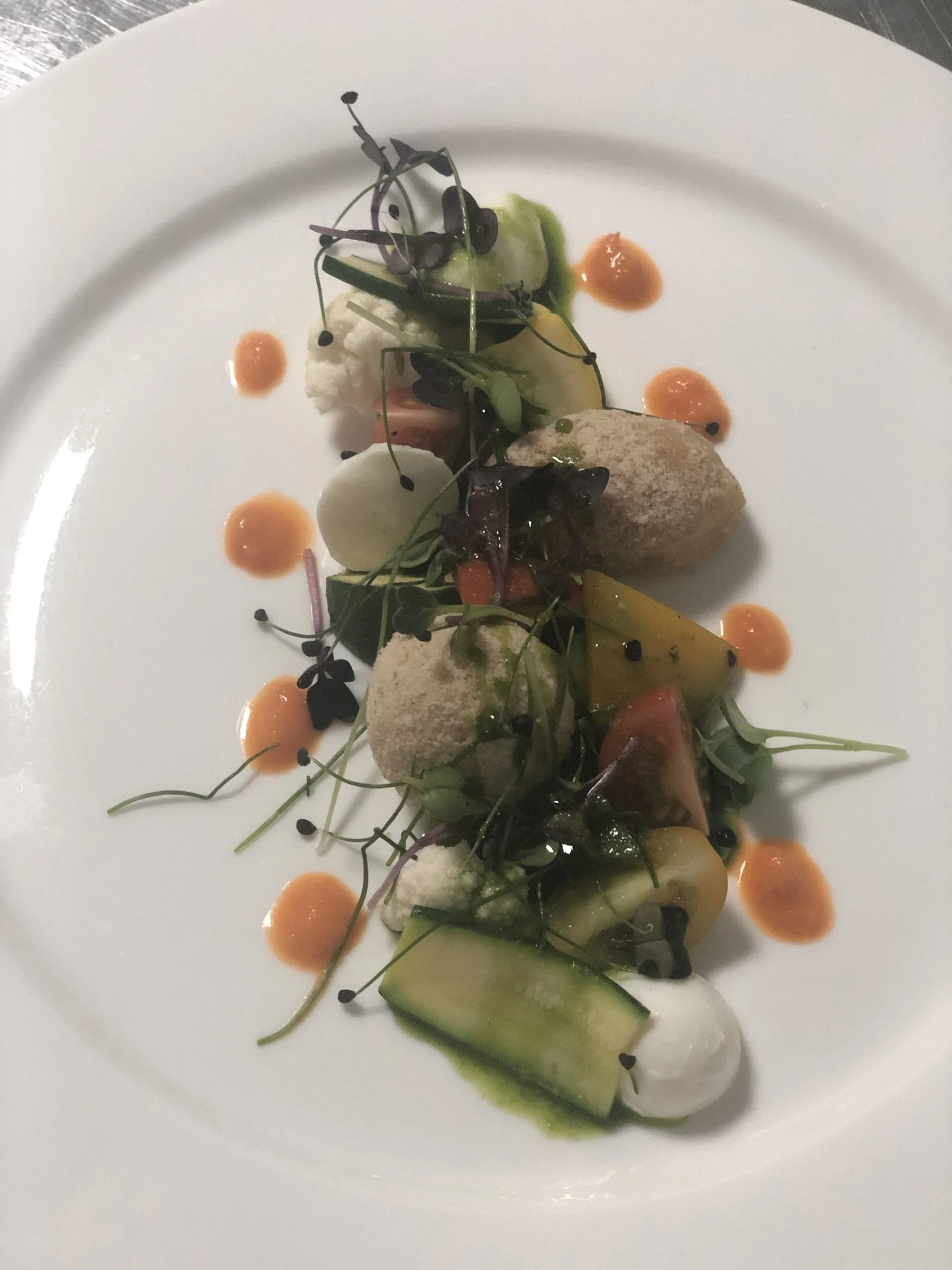 Plated starter with herbs, cucumber and creamy dressing