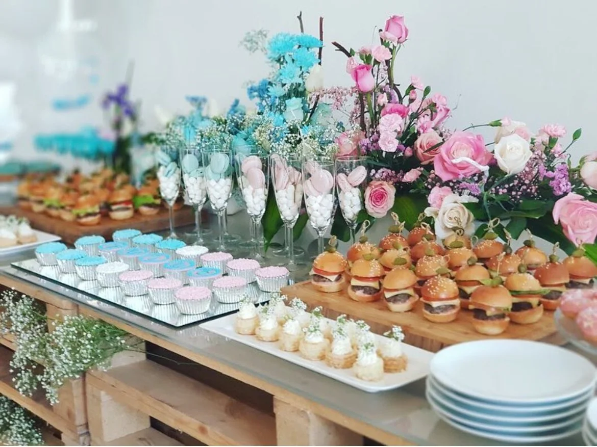 Pastel dessert and canapé table with flowers and sliders