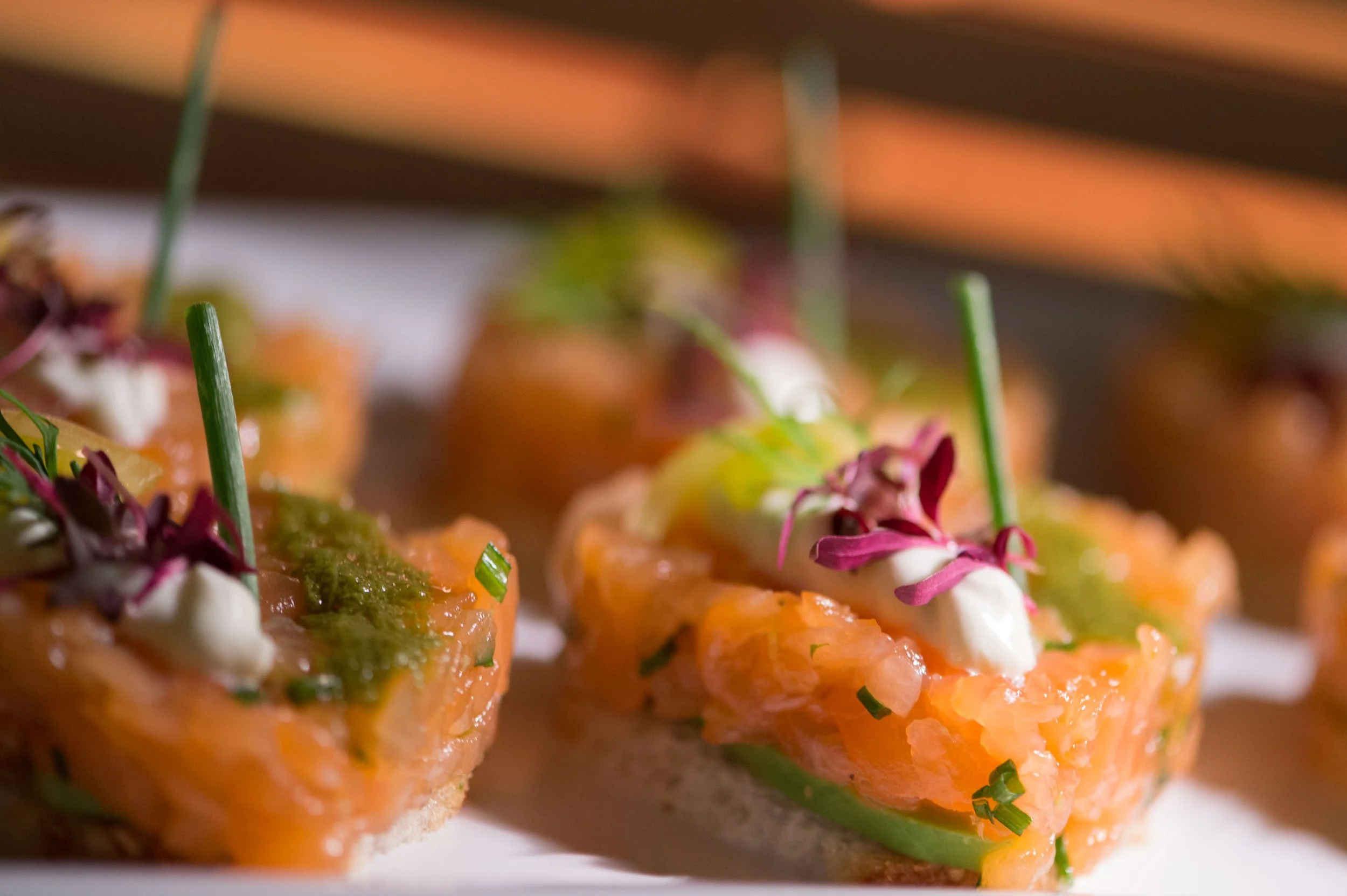 Salmon tartare canapés topped with herbs and cream