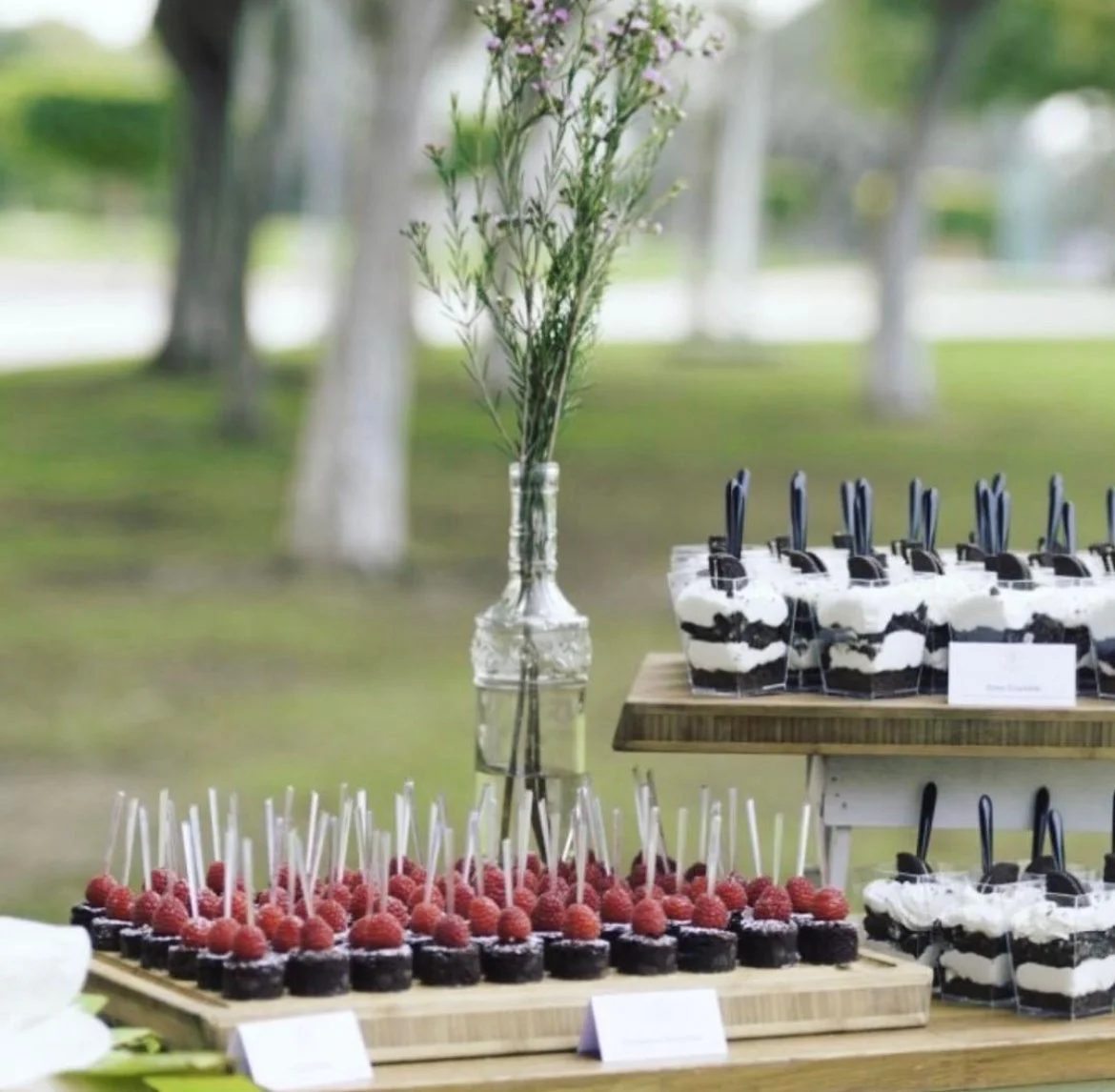 Berry dessert pots on a table laid out on a sunny lawn