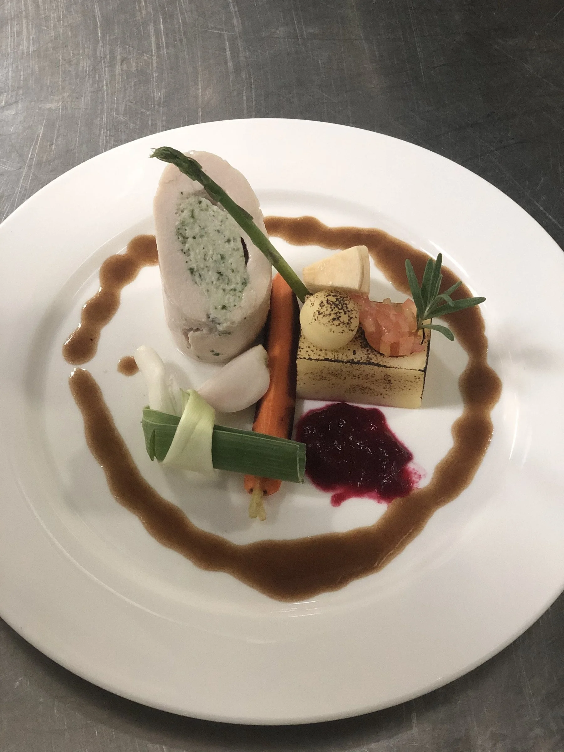 Layered terrine with garnish and sauce swirls on a plate