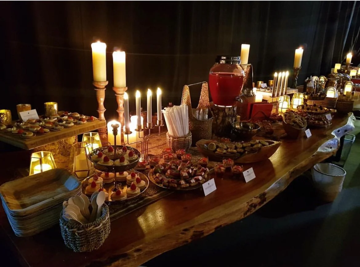 Candlelit wooden buffet table laden with canapés and drinks