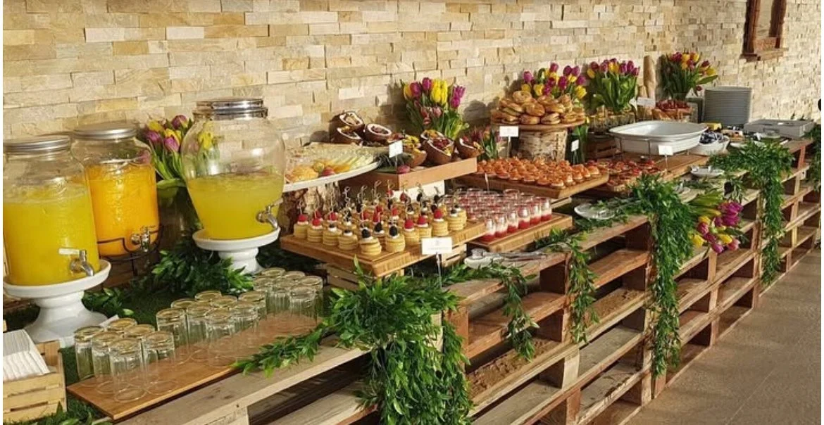 Rustic wooden buffet with juices and canapés among greenery