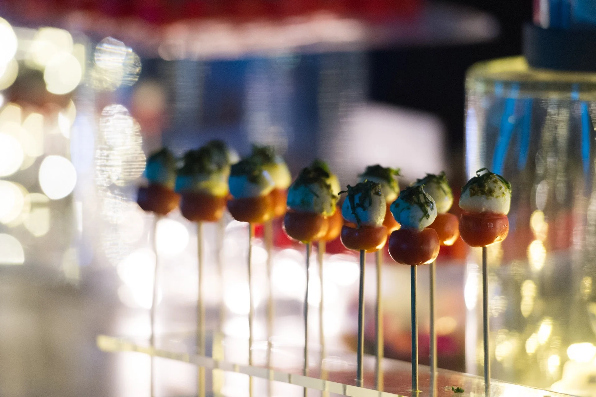 Colourful cake pops on stands with sparkling lights behind