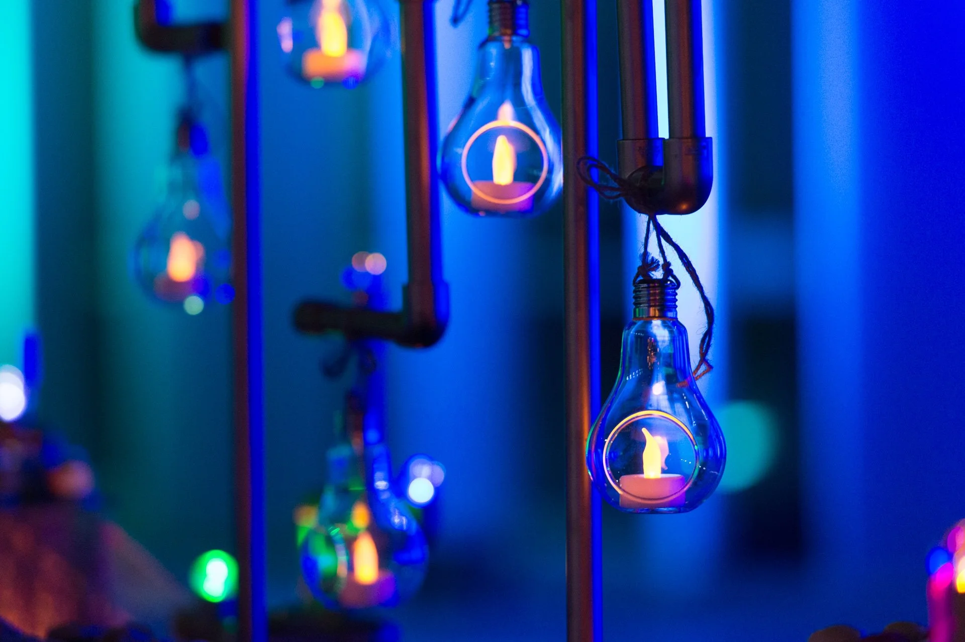 Hanging light bulbs glowing against blue and green backdrop