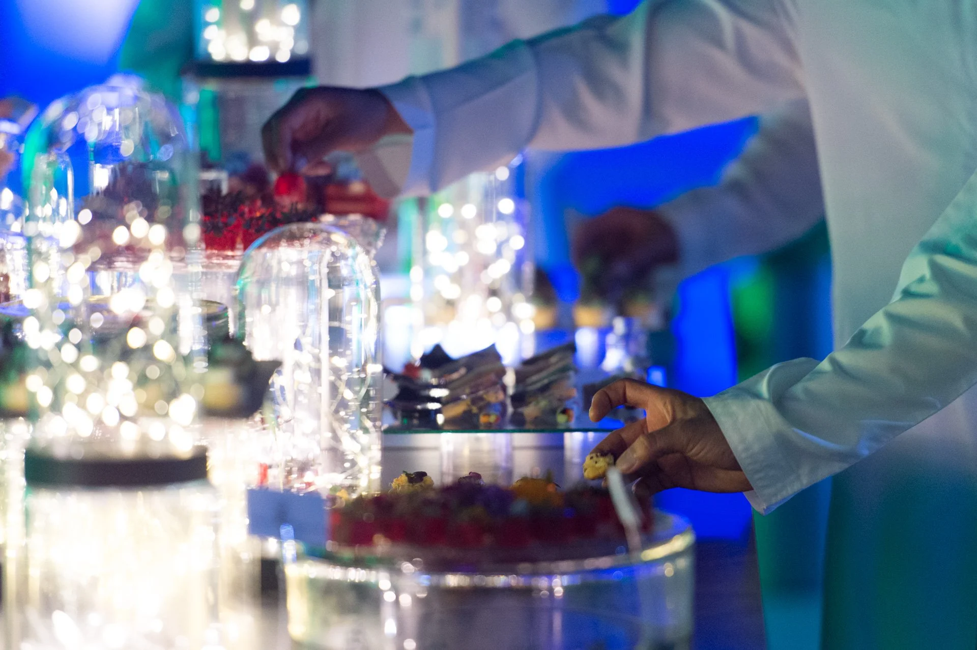 Waiter serving canapés from an illuminated glass display