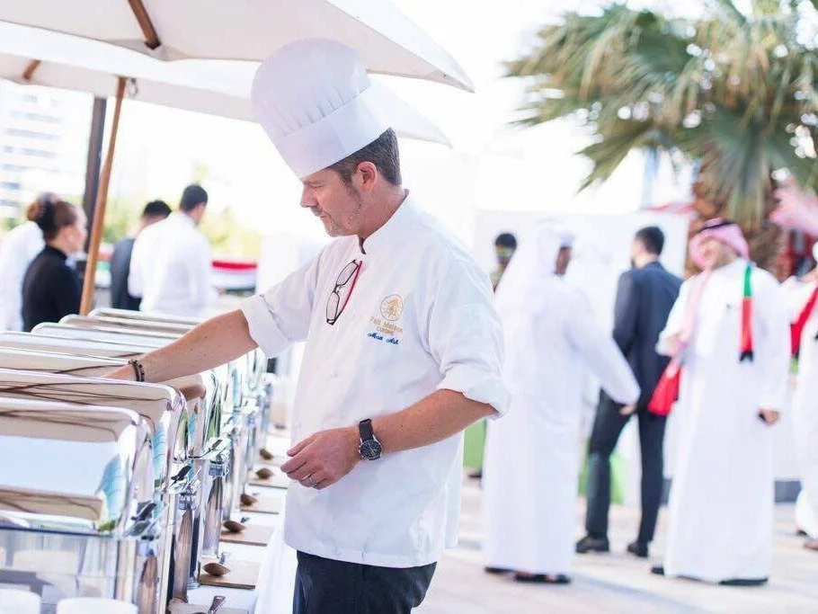 Chef in whites working at an outdoor buffet in Dubai