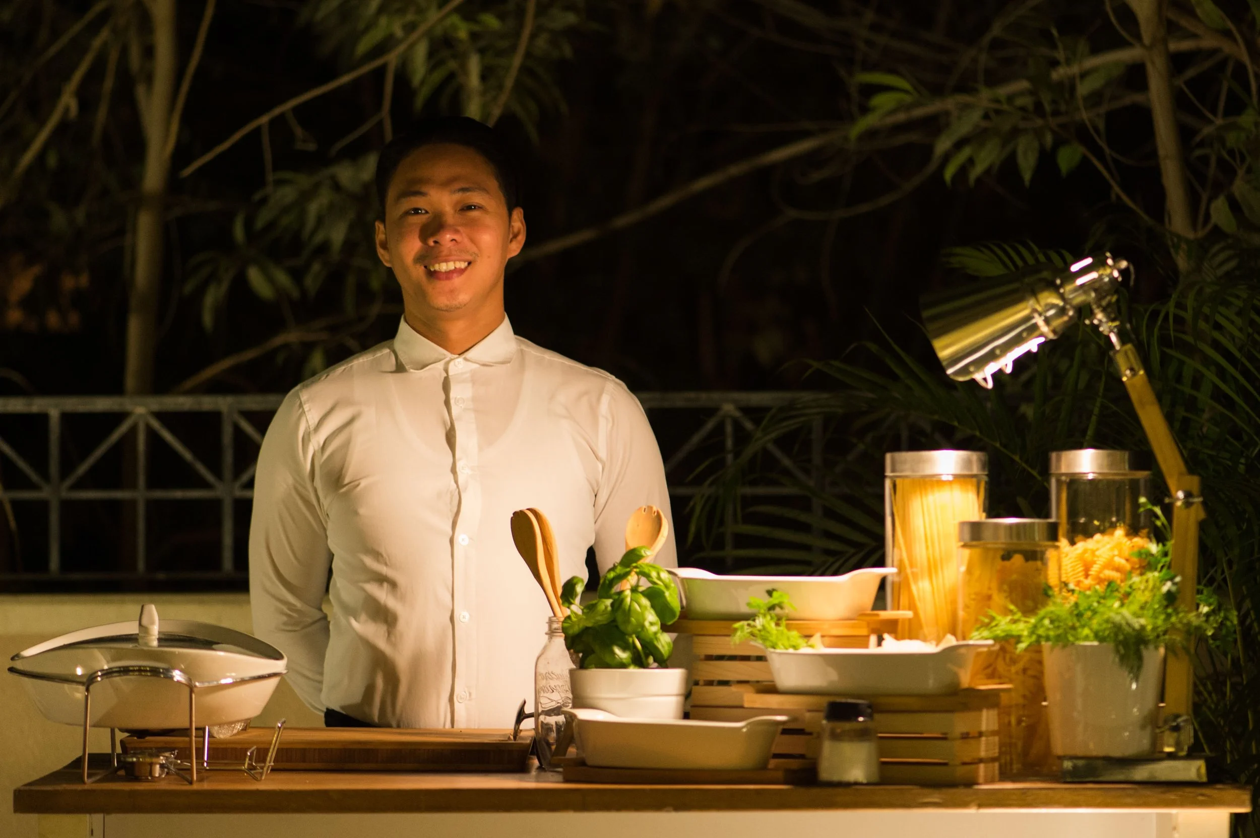 Smiling chef at a live cooking station in a garden