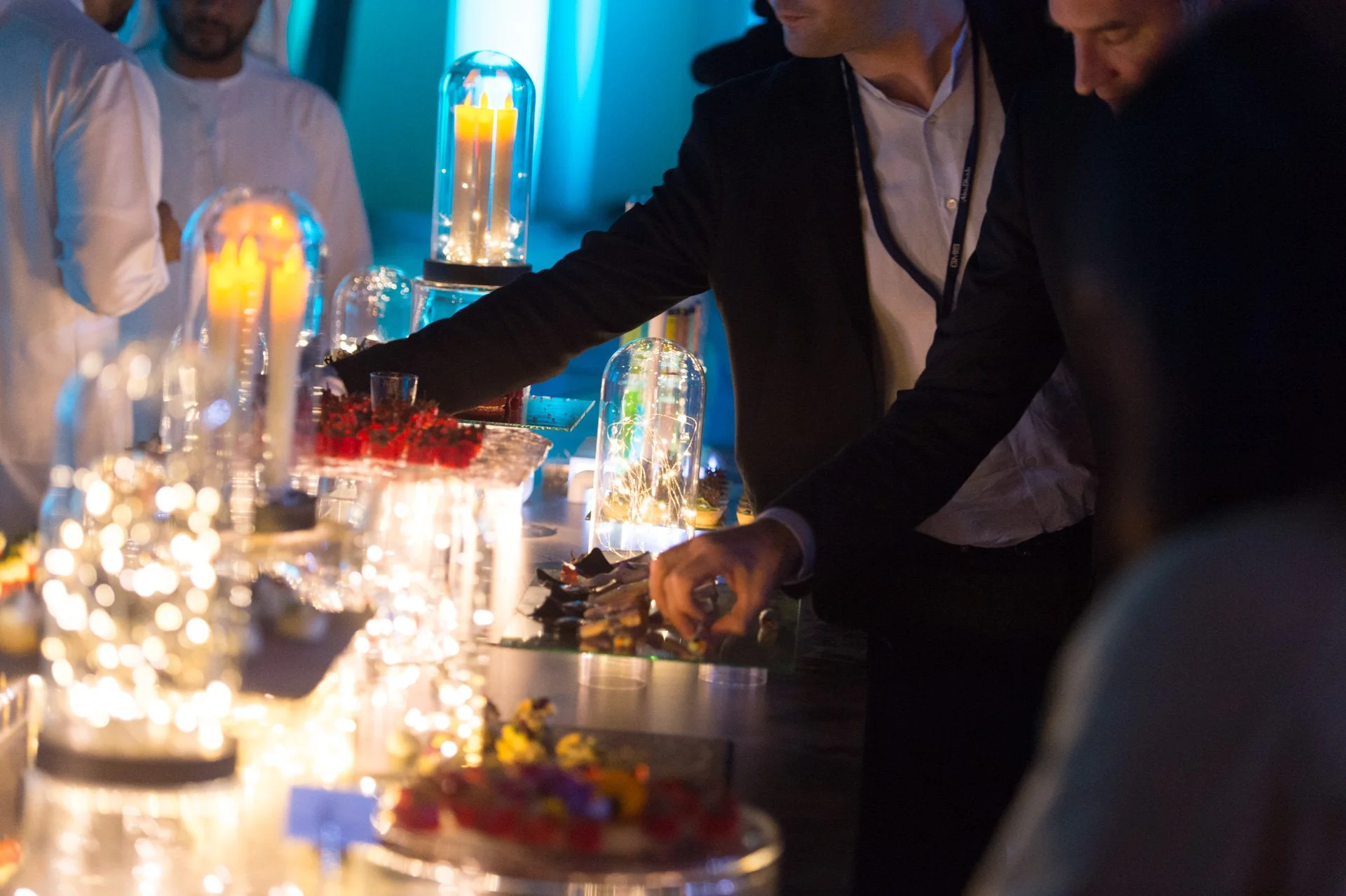 Guests helping themselves to canapés at an illuminated buffet