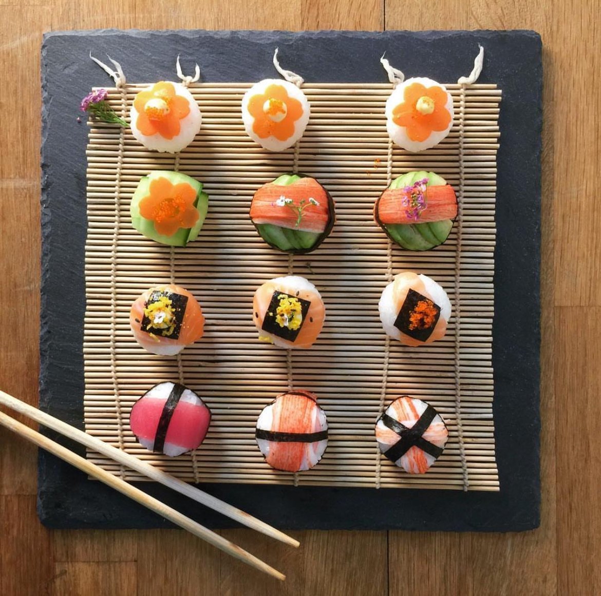 Sushi-style canapés arranged on a bamboo mat and slate