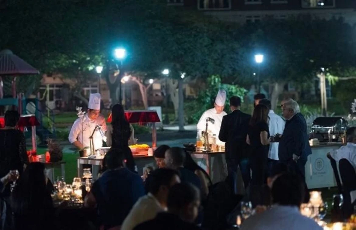 Chefs at live cooking stations at an evening garden event