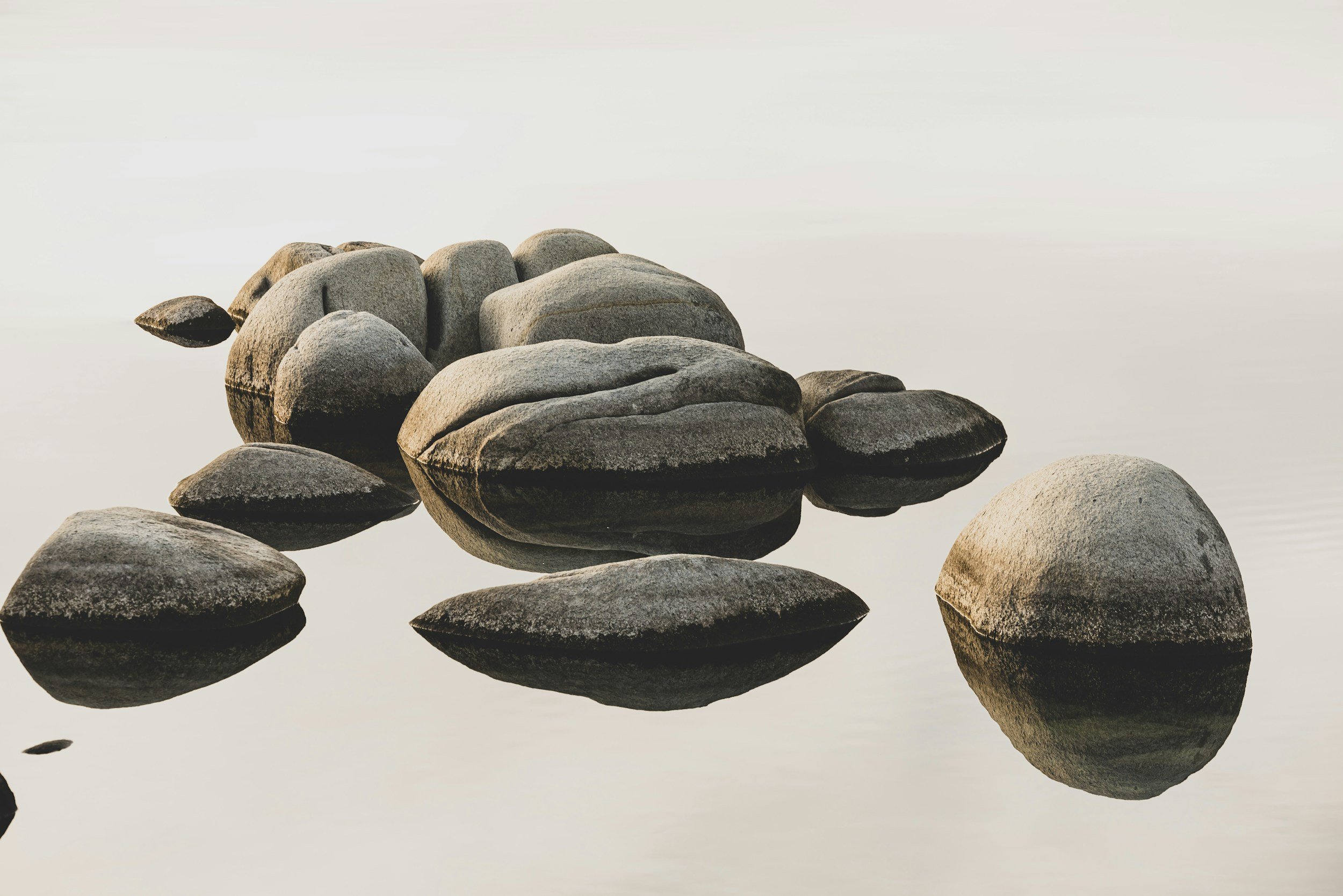 Smooth stones resting in calm, misty water