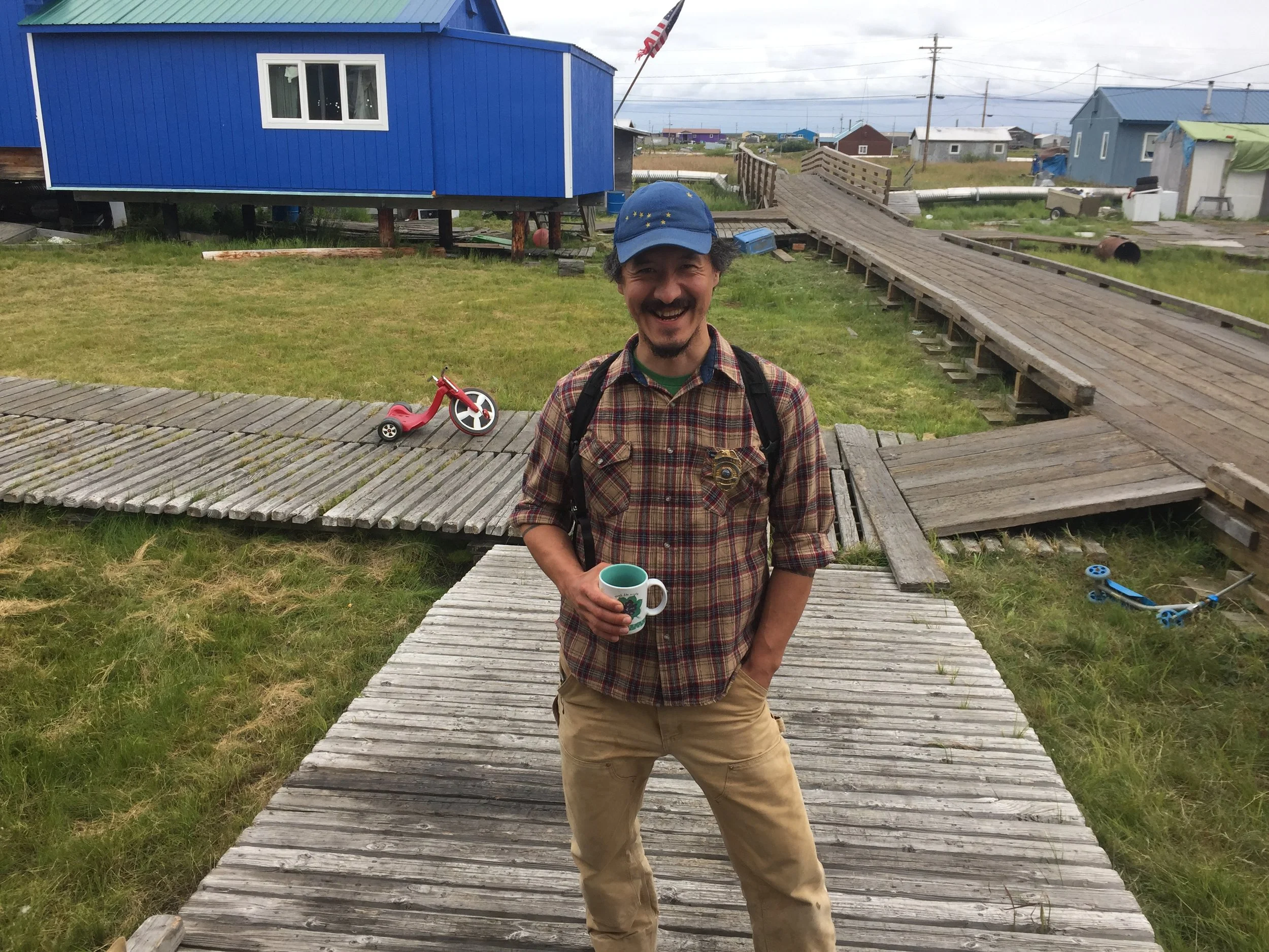 someone standing holding coffee smiling