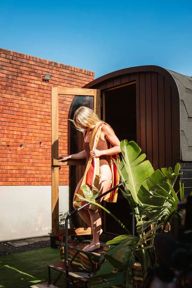 Guest stepping out of the Bondfire sauna door, for private hire