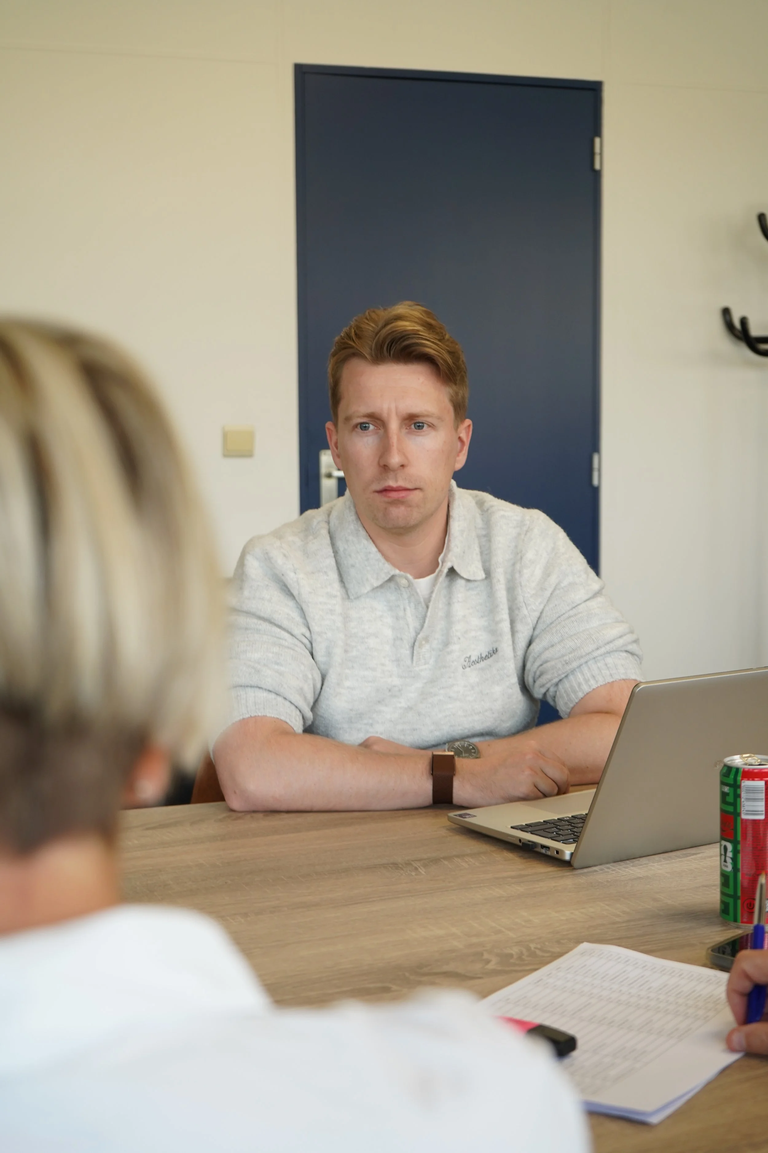 Andy van GDS Trans Service in lichtgrijze trui zit aan een tafel met laptop tijdens een overleg