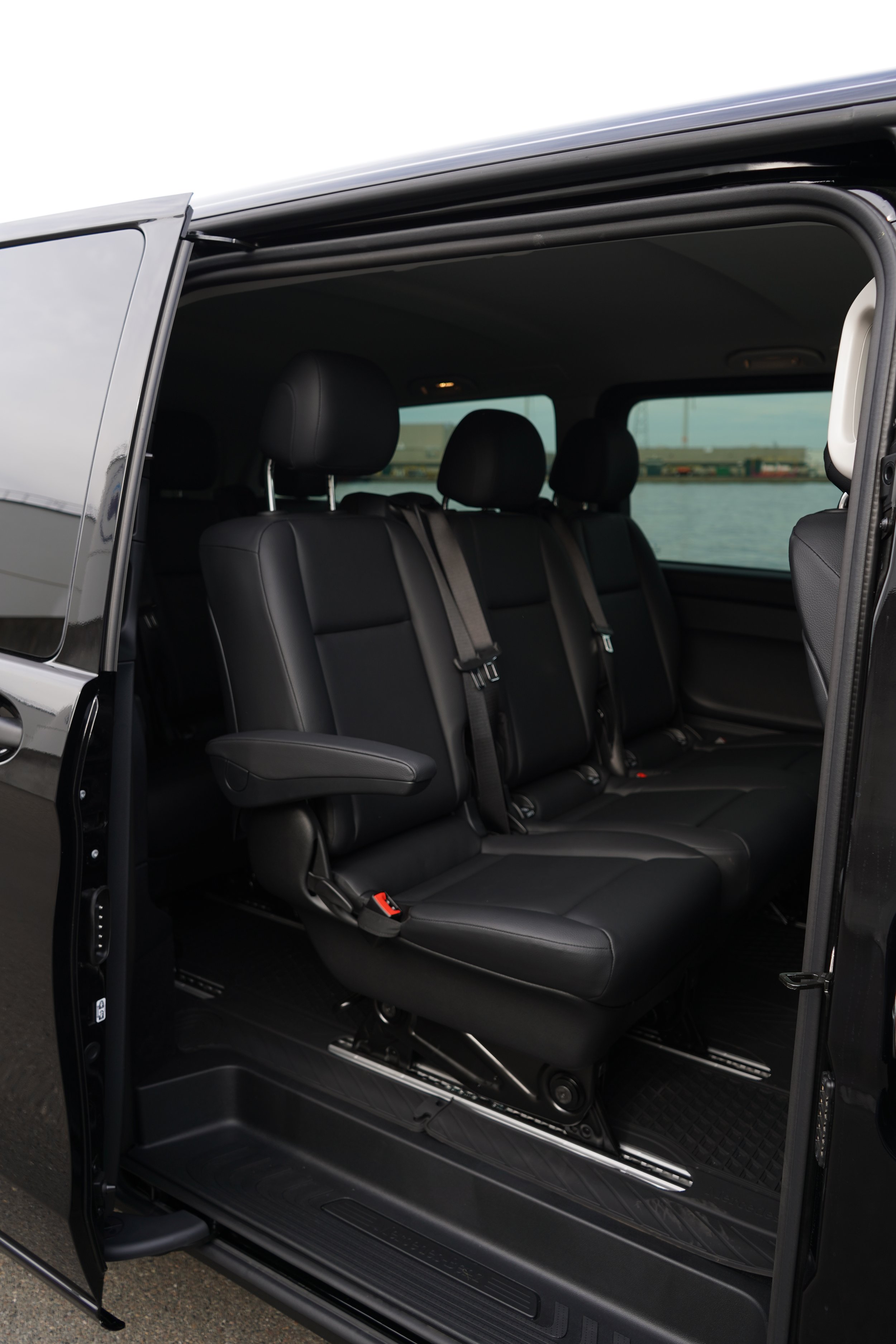 Interieur van een SUV van GDS Trans Service met zwarte leren stoelen en geopende deuren.