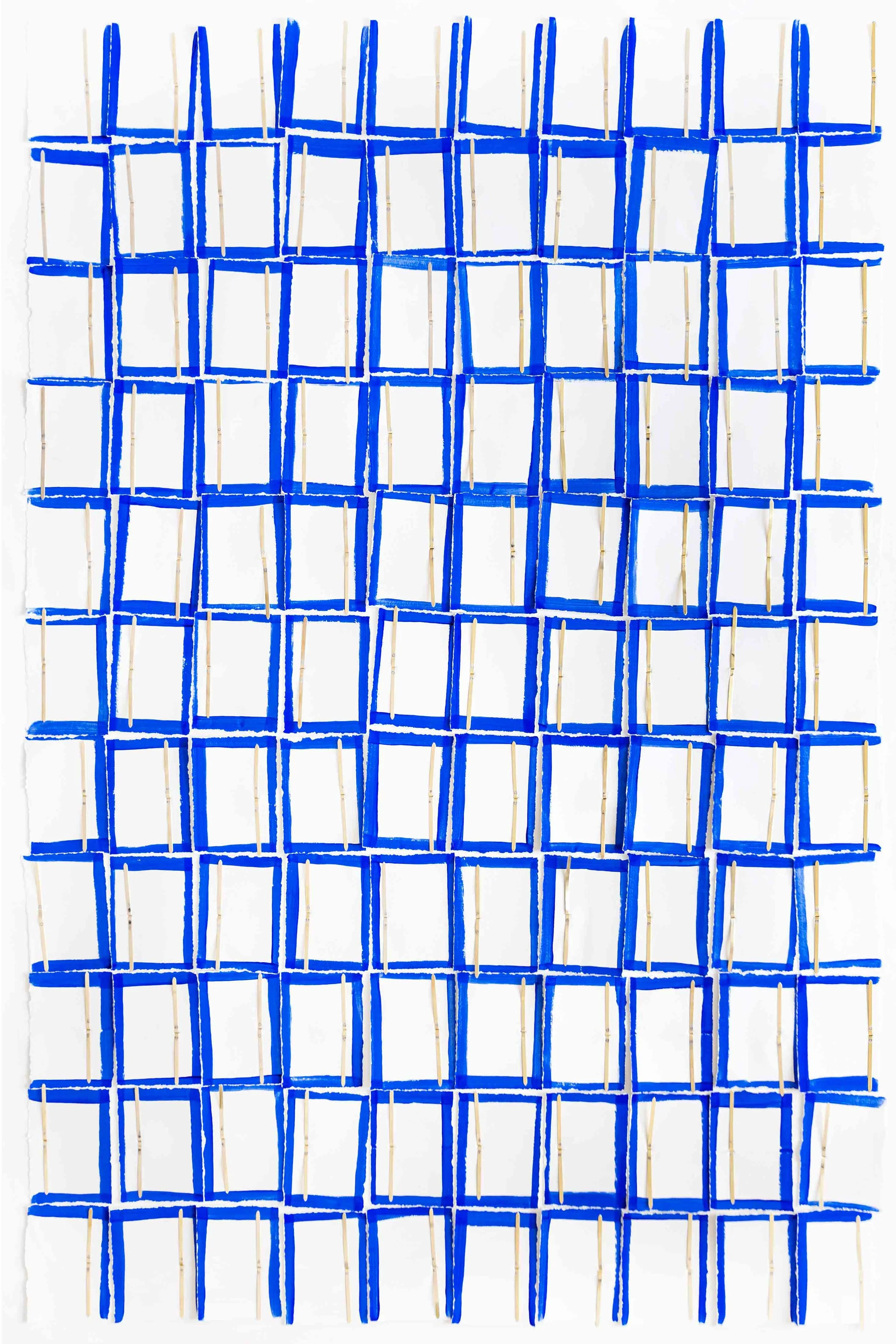 Une œuvre d'art abstraite composée de bandes de papier déchiré peintes en bleu Klein, fixées sur un fond blanc avec des attaches parisiennes.
