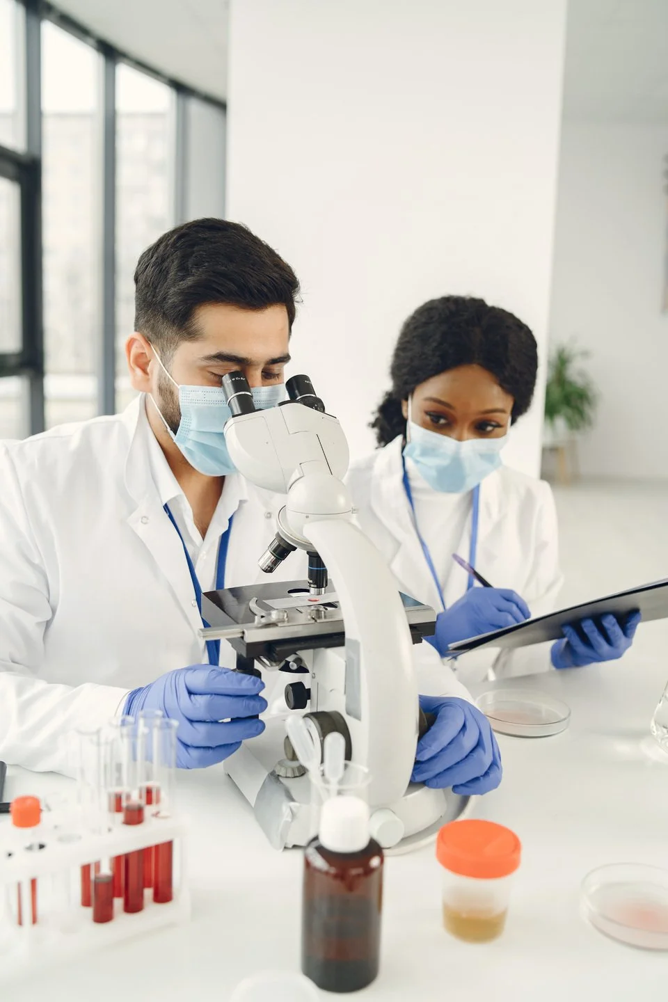 New test. Concentrated skilled researchers wearing uniform. Doing test, creating vaccine.