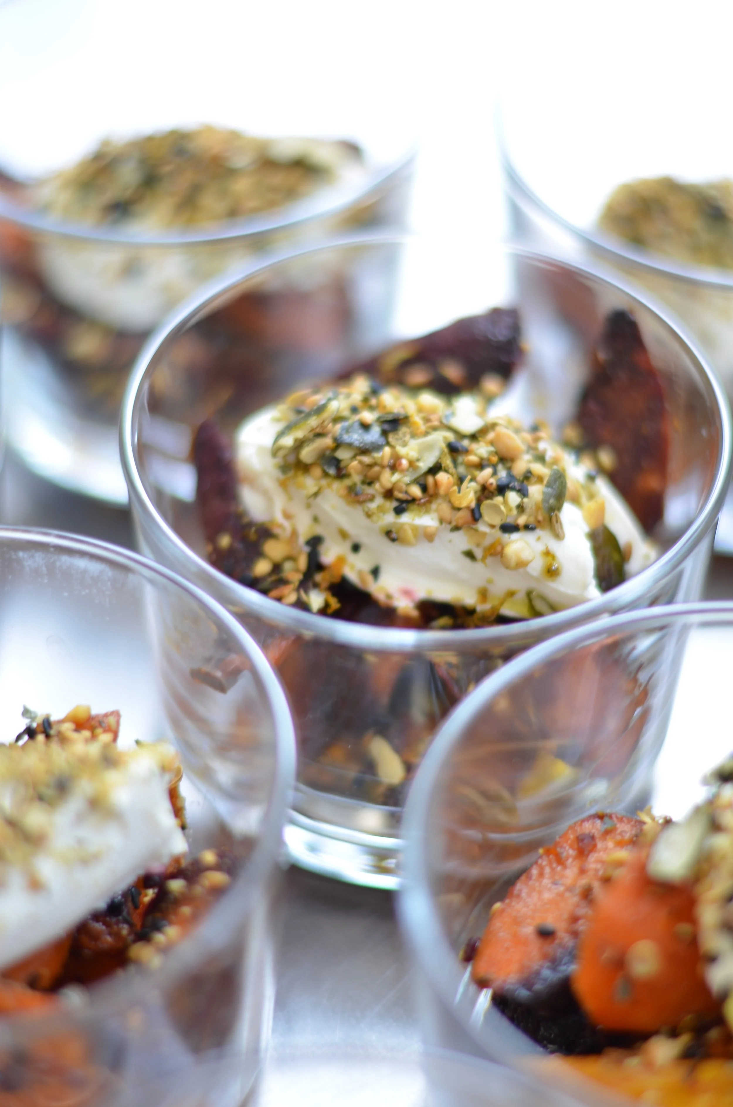 Verschiedene in Gläsern servierte Snacks mit Käse, Nüssen und getrockneten Früchten.