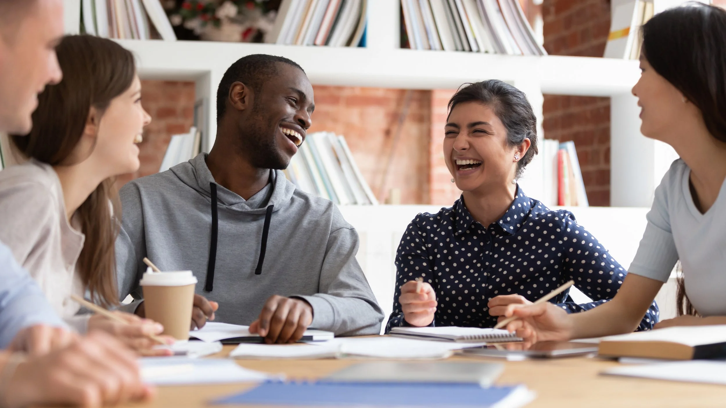 students discussing and laughing around a table