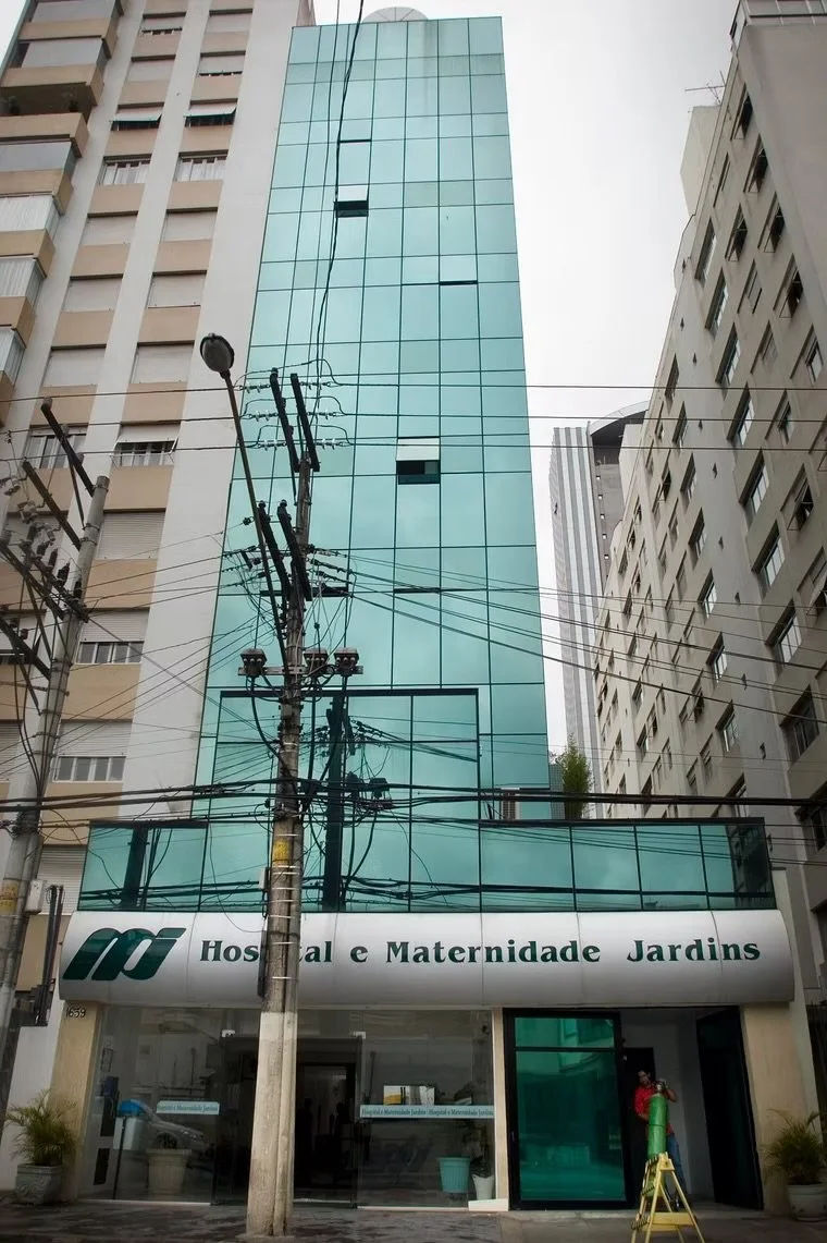 Prédio de vidro com sinalização de Hospital e Maternidade Jardins na entrada.
