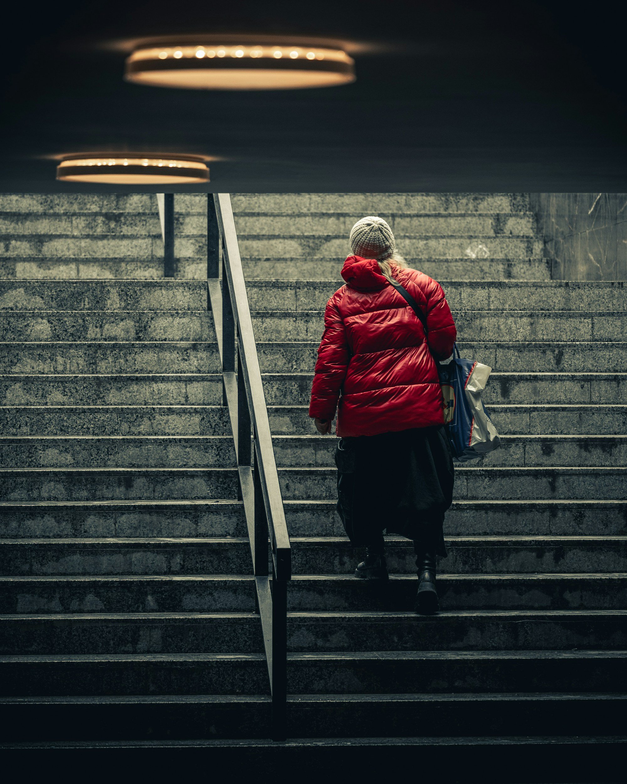 Oudere vrouw loopt met moeite een trap op